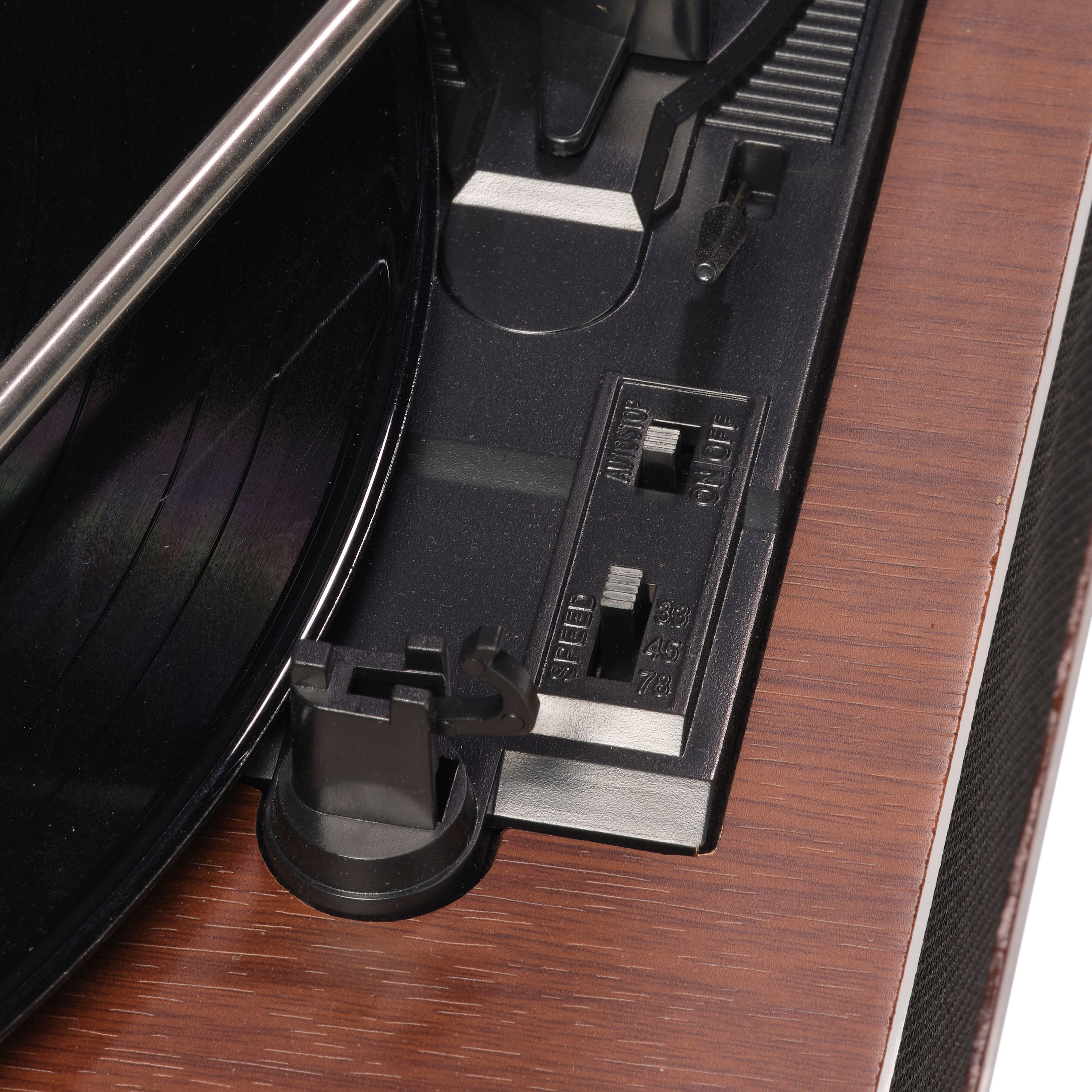 Gros plan sur une platine vinyle. Montre le bras, le sélecteur de vitesse et la base en grain de bois.