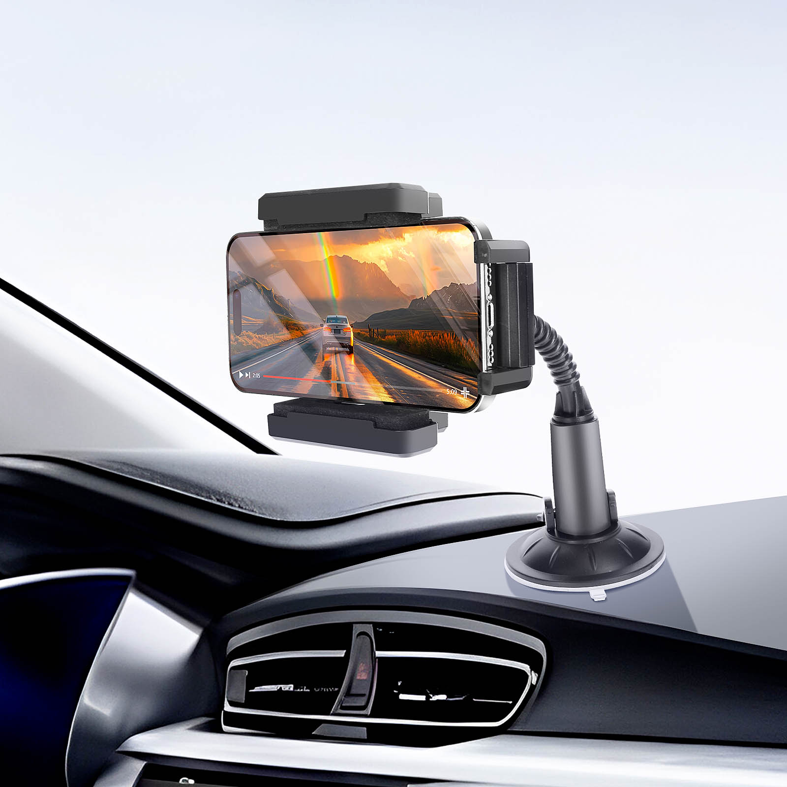 Ein Telefon in einer Autohalterung zeigt ein Video von einem Auto auf einer Straße mit Regenbogen.