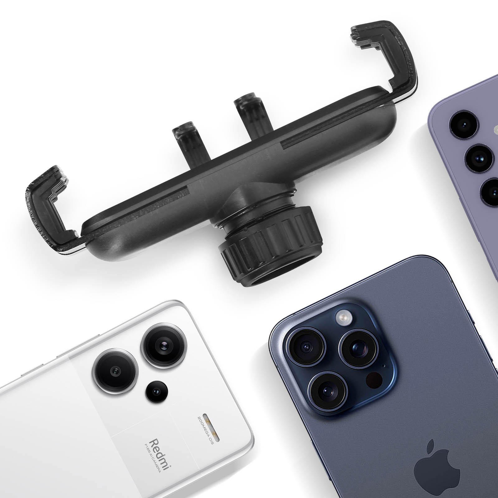 Eine Telefonhalterung und drei Smartphones sind auf einer weißen Oberfläche angeordnet. Telefone sind weiß, lila und blau.
