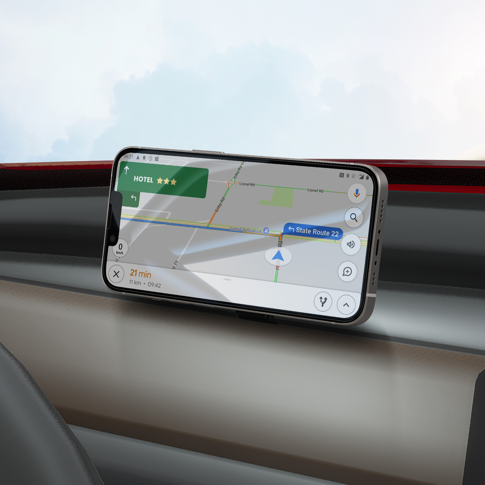 Un teléfono muestra una app de navegación con una ruta a un hotel. Está montado en un coche, con el cielo de fondo.