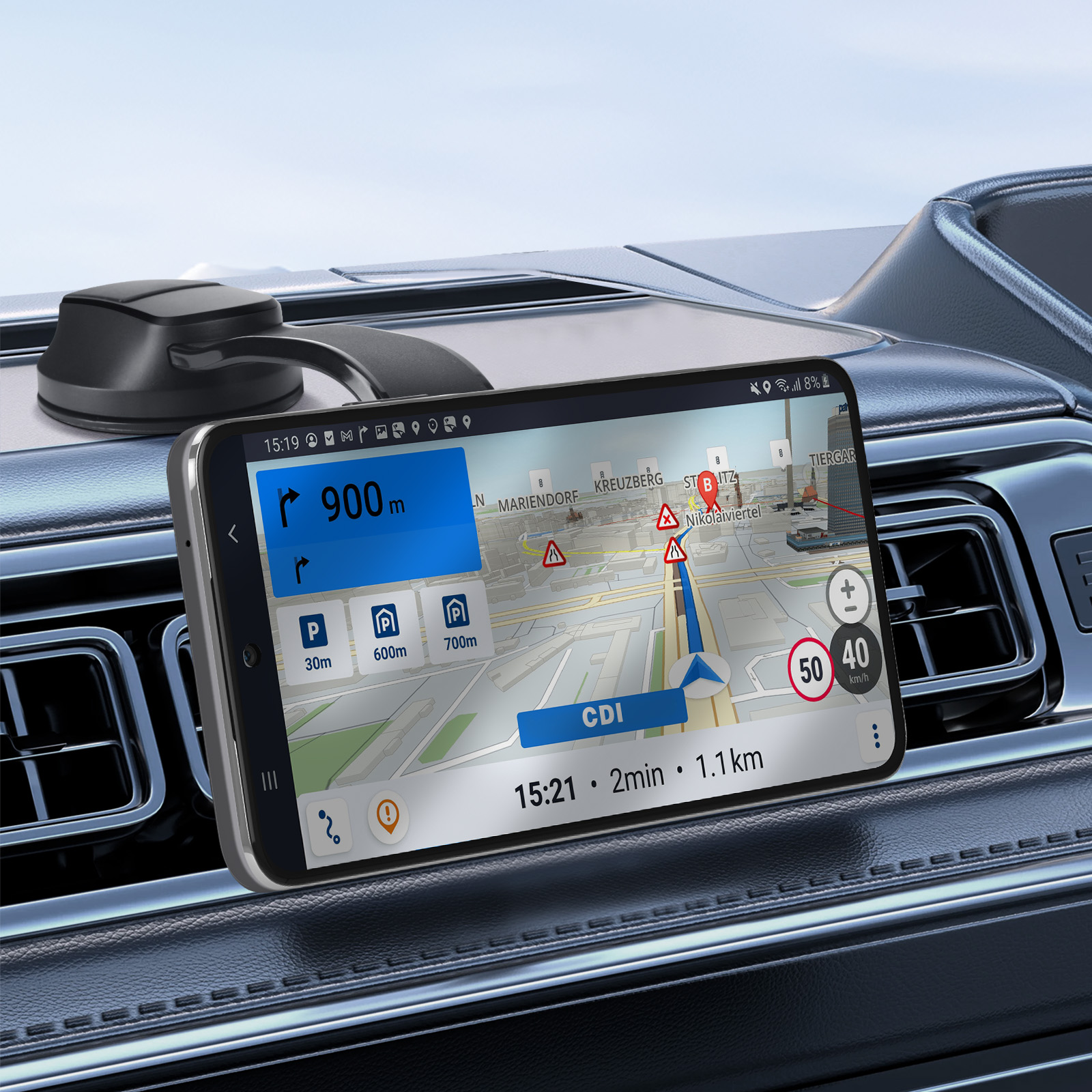Un telefono che mostra una mappa di navigazione è montato sul cruscotto di un'auto. Lo schermo mostra indicazioni, velocità e distanza.