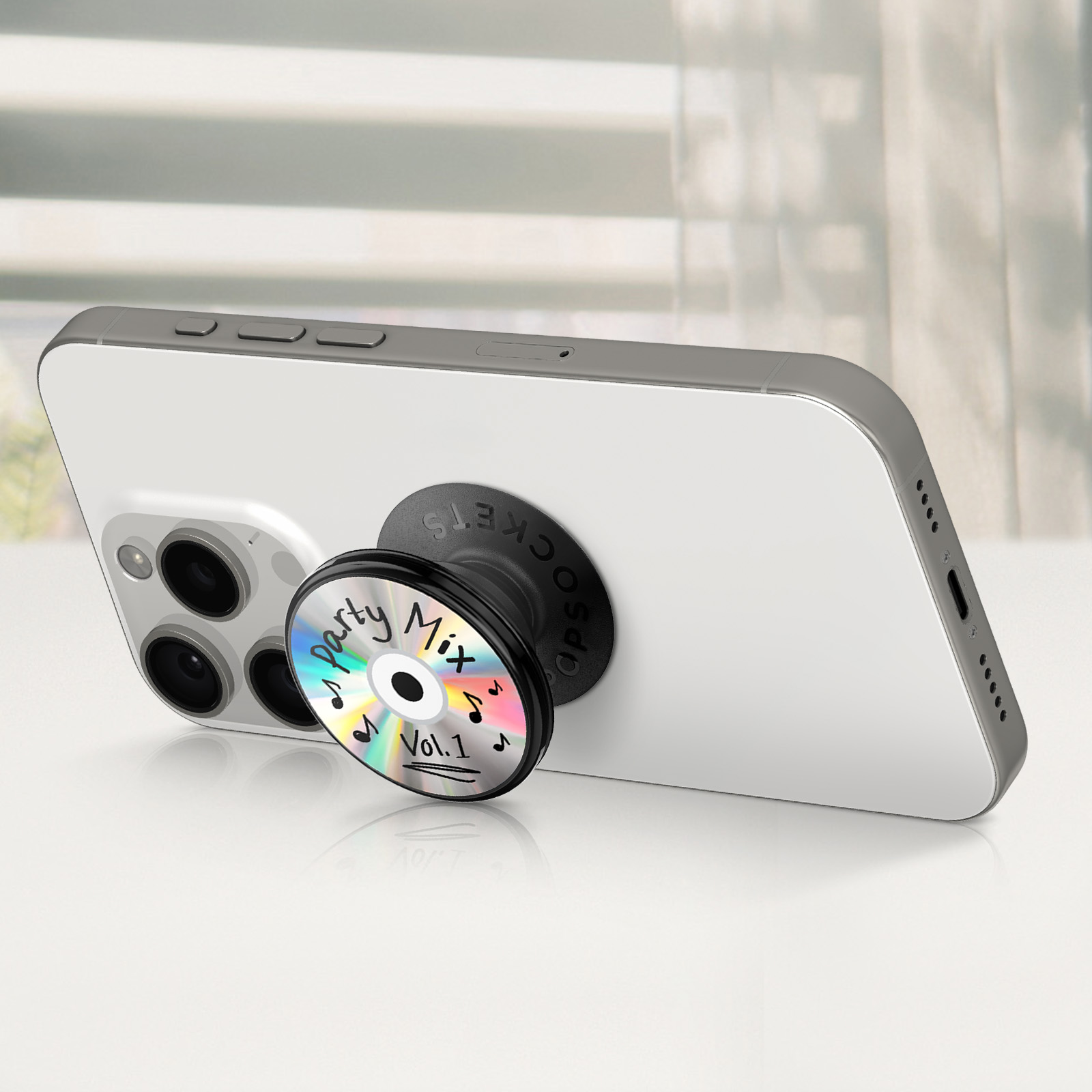 Ein weißes Telefon mit einem Party-Mix-CD-PopSocket. Die CD hat Noten und Vol.1 darauf.