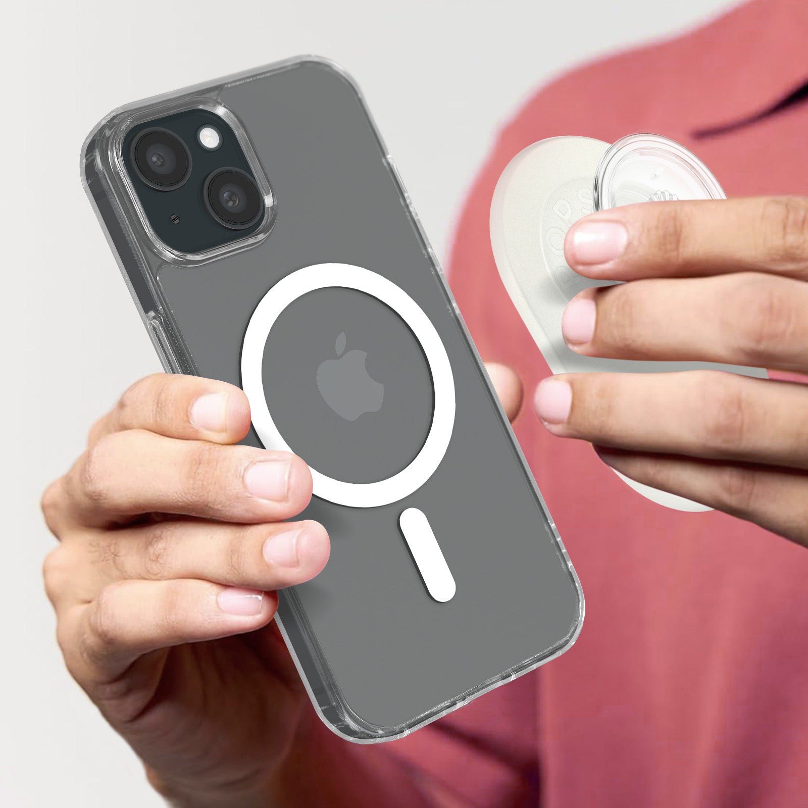 Una persona sostiene un teléfono con una funda transparente y un accesorio circular blanco. El teléfono tiene un logotipo de Apple.