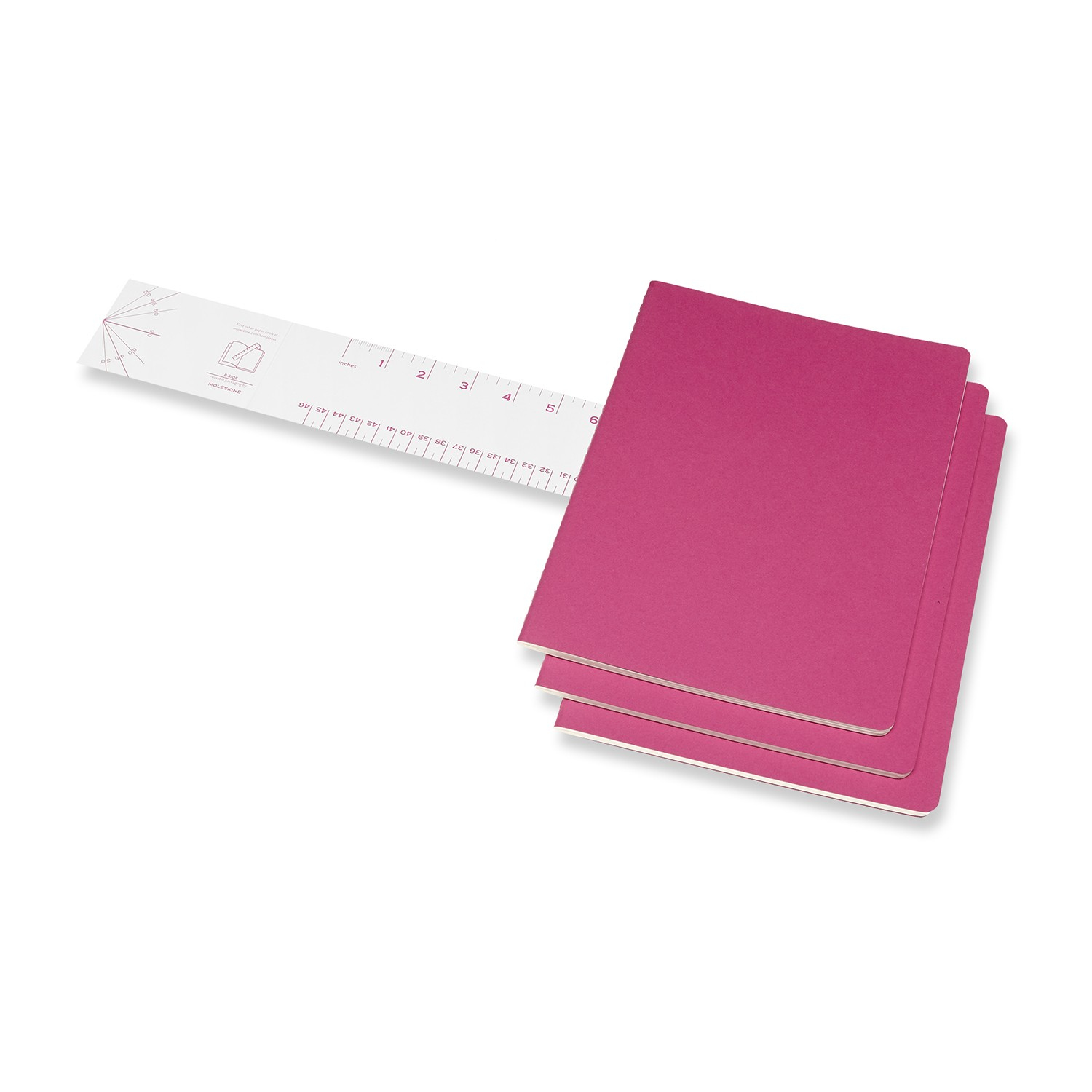 Ein Lineal liegt neben drei pinkfarbenen Notizbüchern. Das Lineal ist weiß, mit Messungen in Zoll und Zentimetern.