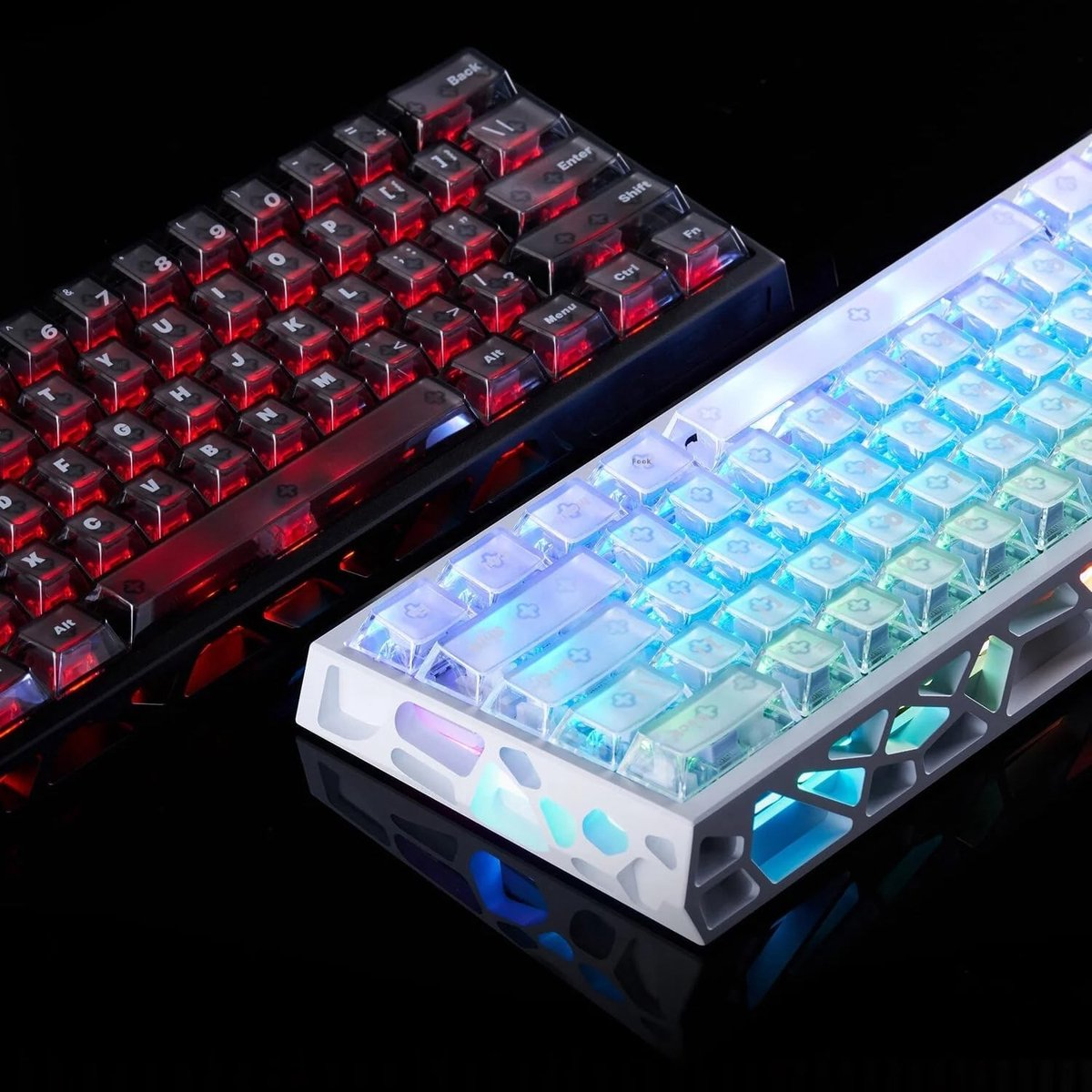 Two illuminated mechanical keyboards. One red, one blue/green. Both have transparent keycaps with visible switches and internal lighting.