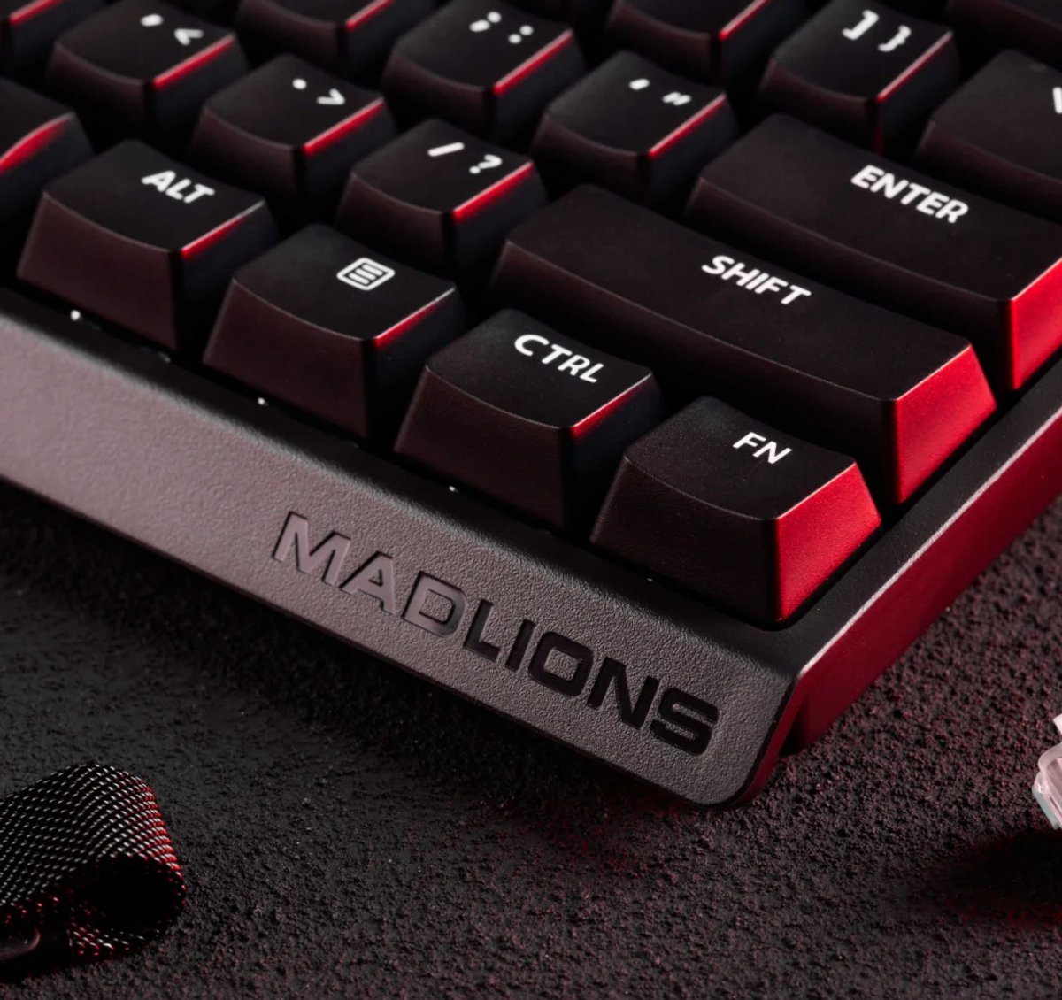 Close-up van een zwart toetsenbord met rode accenten. Toetsen zoals Ctrl, Shift en Enter zijn zichtbaar. Het Mad Lions-logo staat erop.