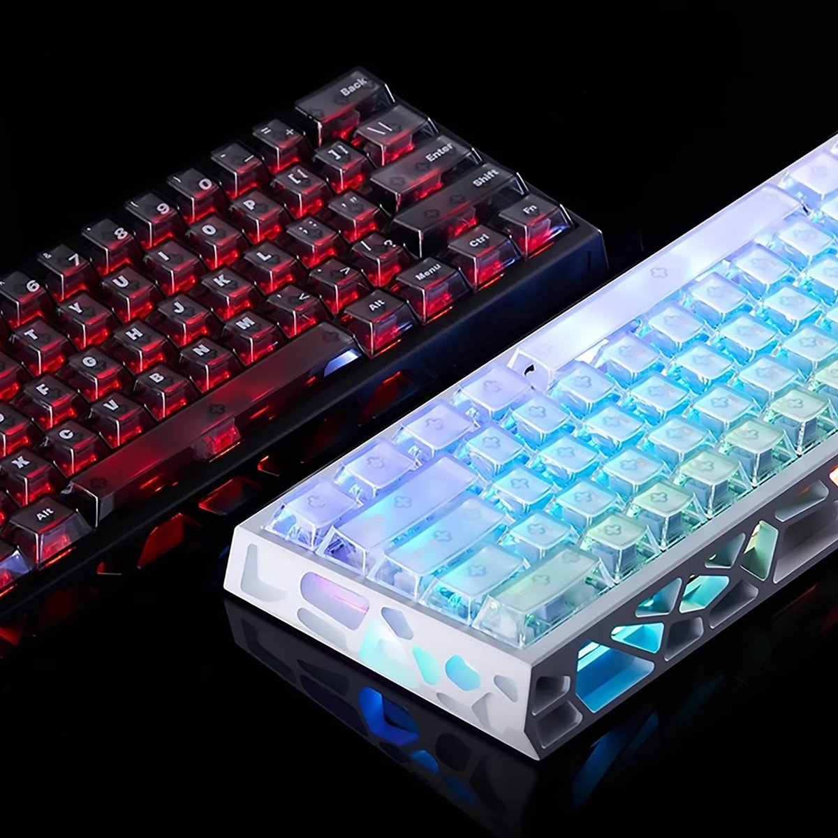 Two illuminated keyboards. One red-lit, the other blue-lit. Both have clear keycaps. They are on a reflective black surface.