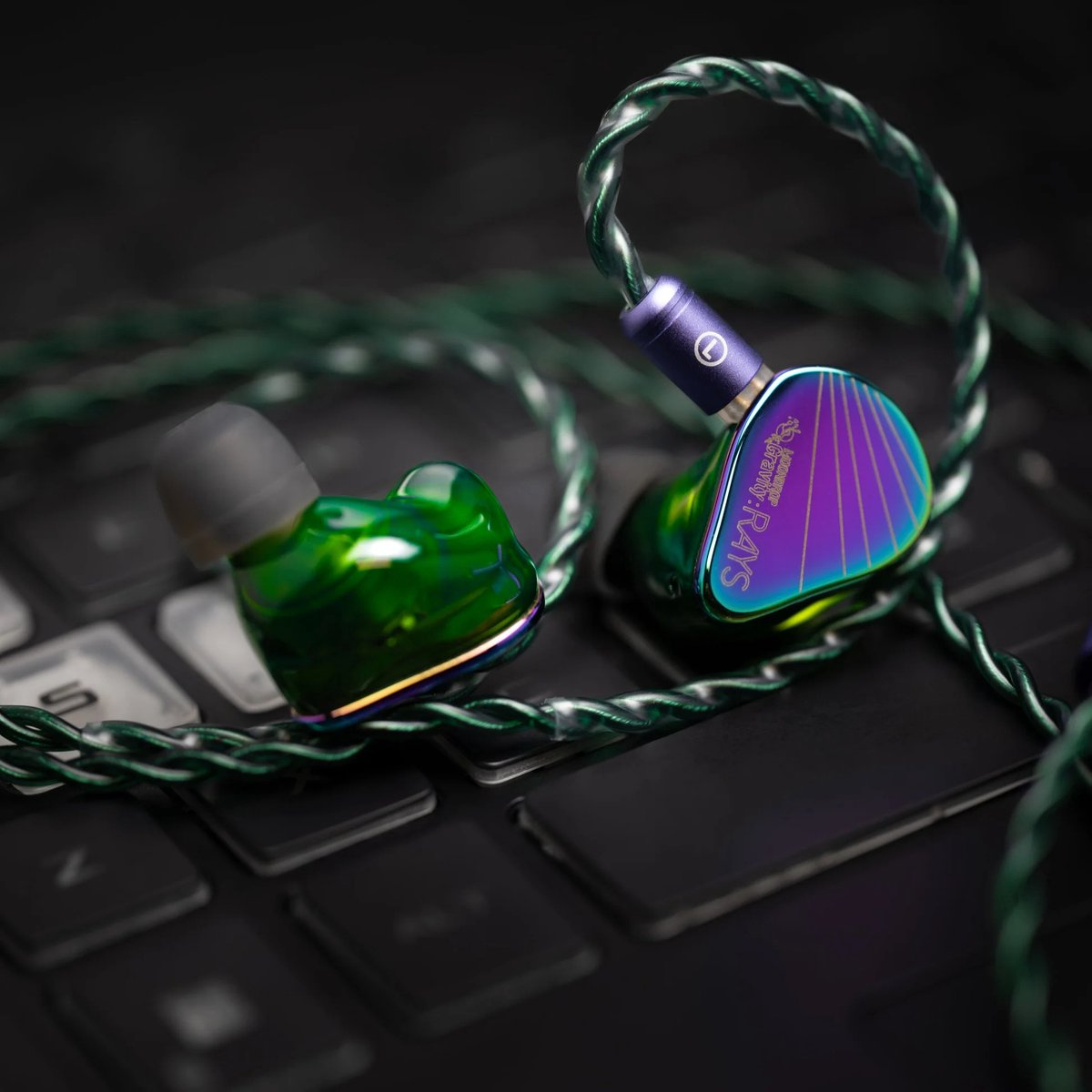 Oortelefoons met groene en iriserende afwerking op een toetsenbord. De draad is groen en de oortelefoons hebben een uniek ontwerp.