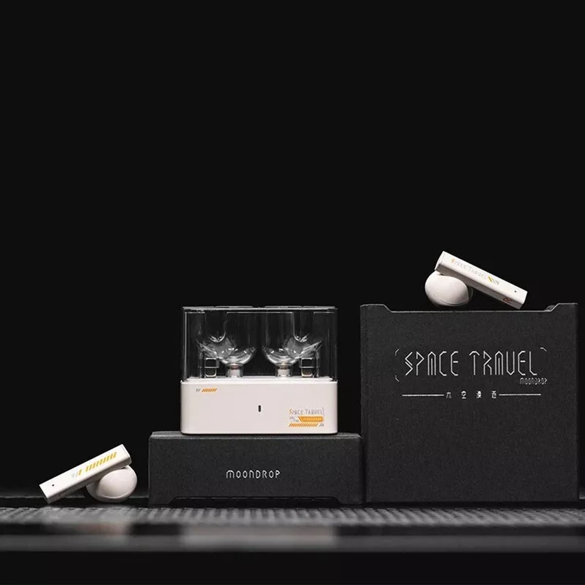 Eine Produktpräsentation mit einem weißen Gerät mit zwei Gläsern, einer Box mit dem Text 'SPACE TRAVEL' und anderen kleinen Gegenständen.