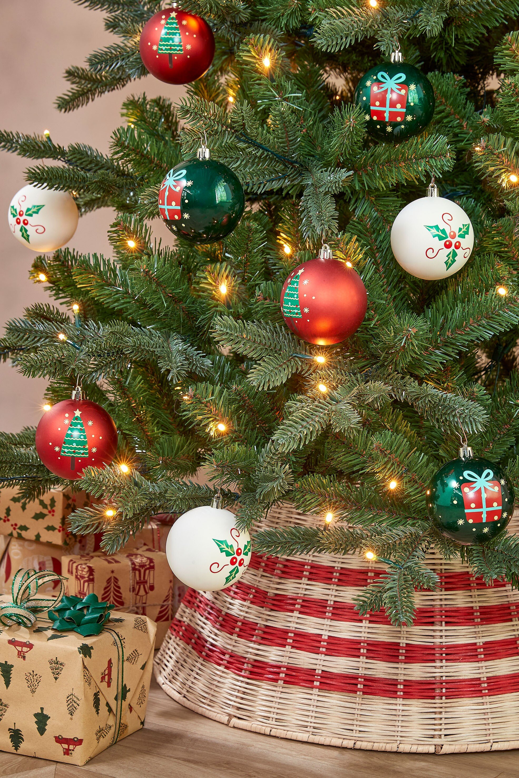Arbre de Noël avec des ornements, des cadeaux et une jupe d'arbre rouge et blanche.