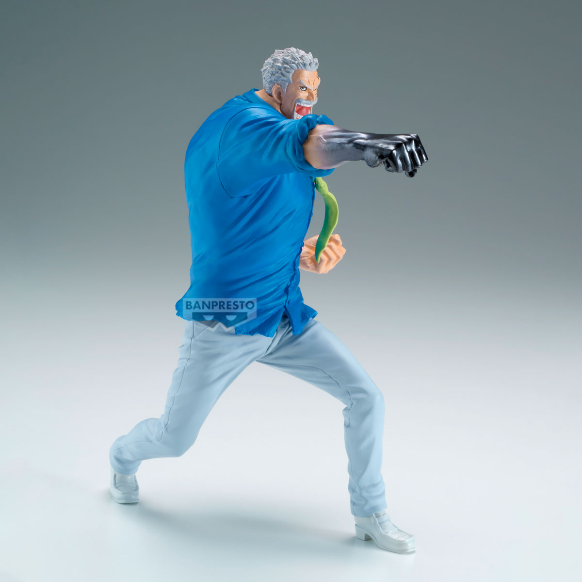 Una statuetta di un uomo in azione. Indossa una camicia blu e pantaloni bianchi, che colpisce con un braccio metallico. Si vede una cravatta verde.