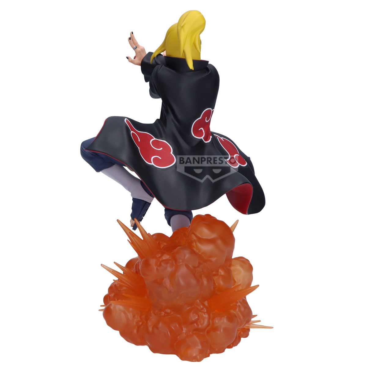 Una statuetta di un personaggio con capelli biondi e un mantello nero con nuvole rosse è in posa sopra un'esplosione arancione.