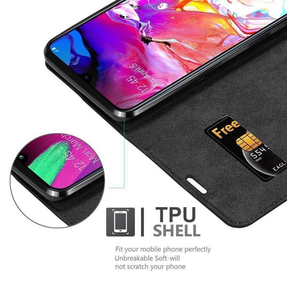 Ein Telefon in einer schwarzen Hülle. Das Display zeigt Datum und Uhrzeit an. Eine kostenlose SIM-Karte befindet sich im Etui. TPU SHELL-Text ist vorhanden.