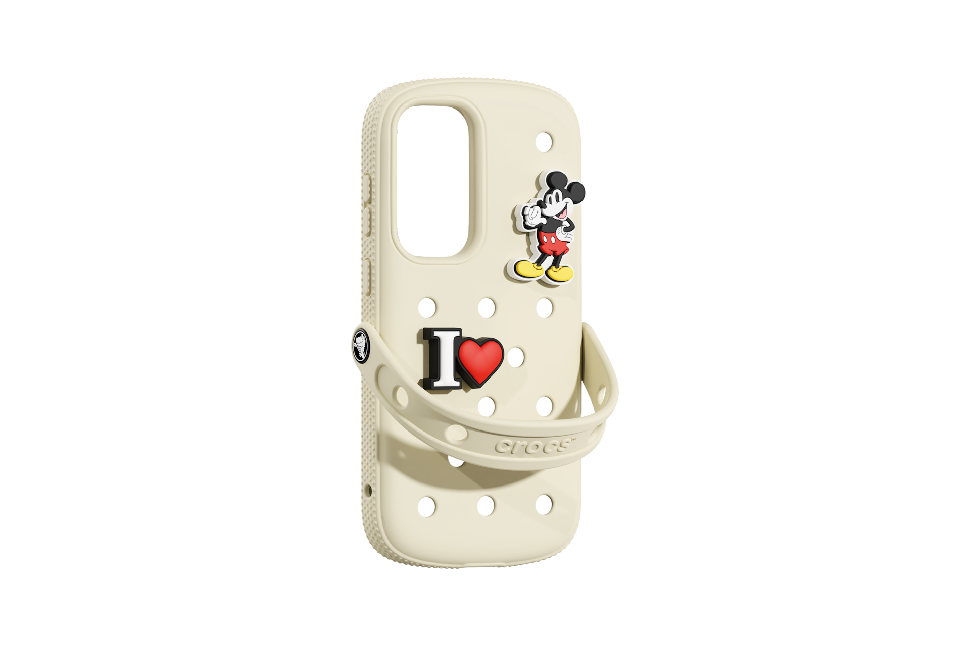 Una scarpa Crocs color crema con ciondoli di Topolino e "I heart". Sfondo nero.