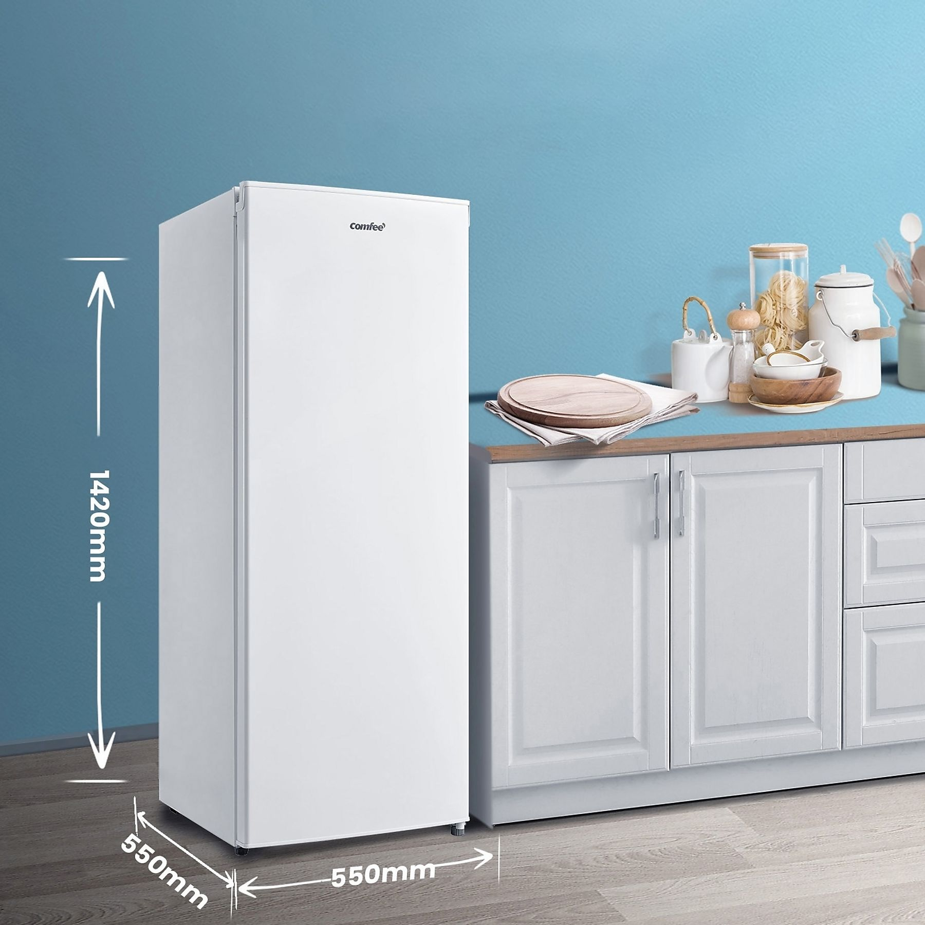 Un frigorifero Comfee bianco è in una cucina. Le dimensioni sono visualizzate. Utensili da cucina e cibo sul bancone.
