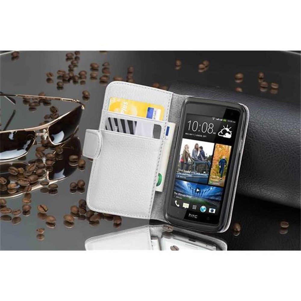 Ein Telefon liegt in einer weißen Hülle mit Kreditkarten. Sonnenbrille und Kaffeebohnen liegen auf einer reflektierenden Oberfläche. Schwarzes Leder ist sichtbar.