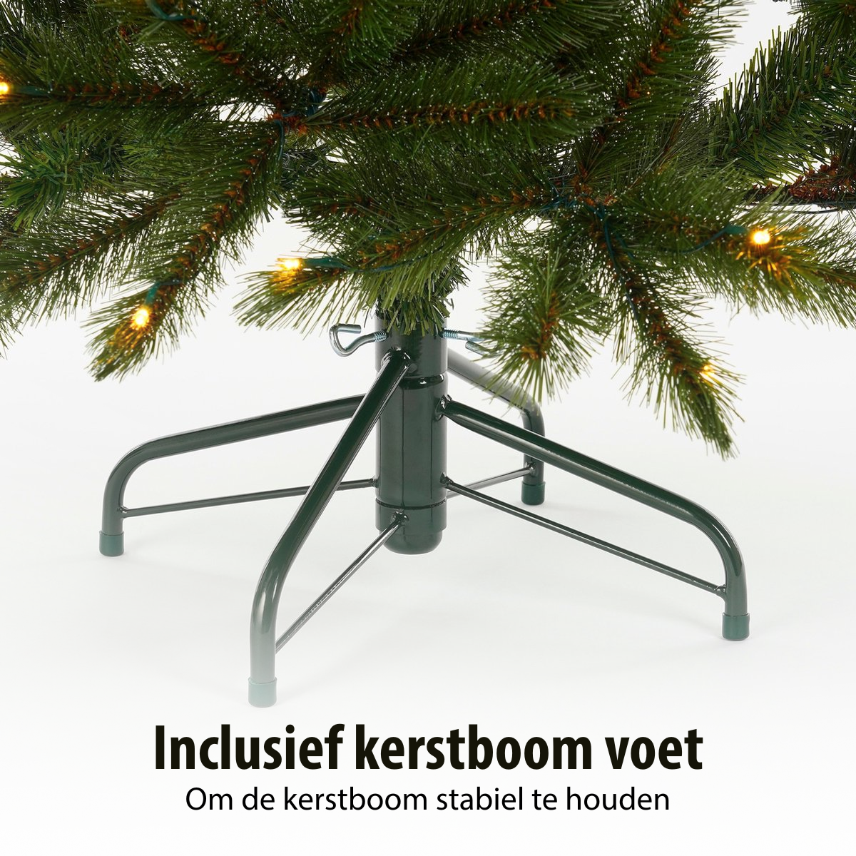 Een groene kerstboomvoet met een metalen standaard. De boom is versierd met lampjes. Tekst onderaan: Inclusief kerstboomvoet.