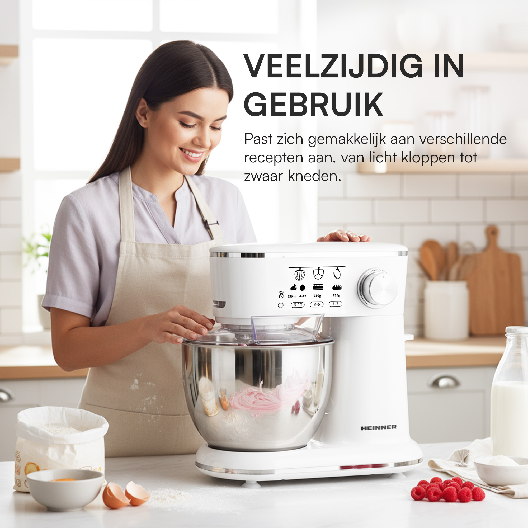 Een vrouw gebruikt een witte keukenmixer. Ingrediënten zoals bloem, eieren en frambozen staan op het aanrecht.