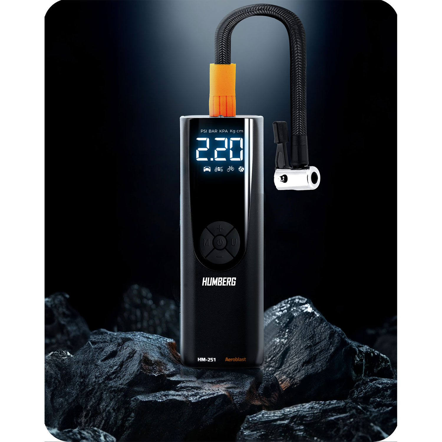 Czarny cyfrowy inflator opon wyświetla 2.20. Ma czarny wąż, pomarańczowe złącze i spoczywa na ciemnych skałach na czarnym tle.