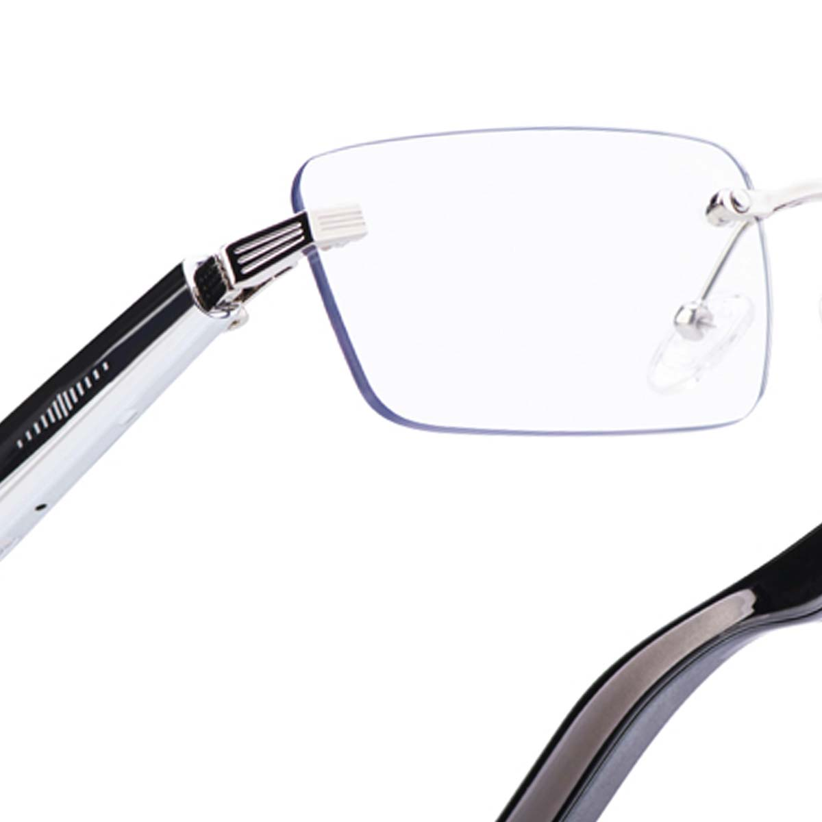 Nahaufnahme einer randlosen Brille. Silberner Rahmen, klare Gläser und schwarzer Bügel. Der Hintergrund ist weiß.