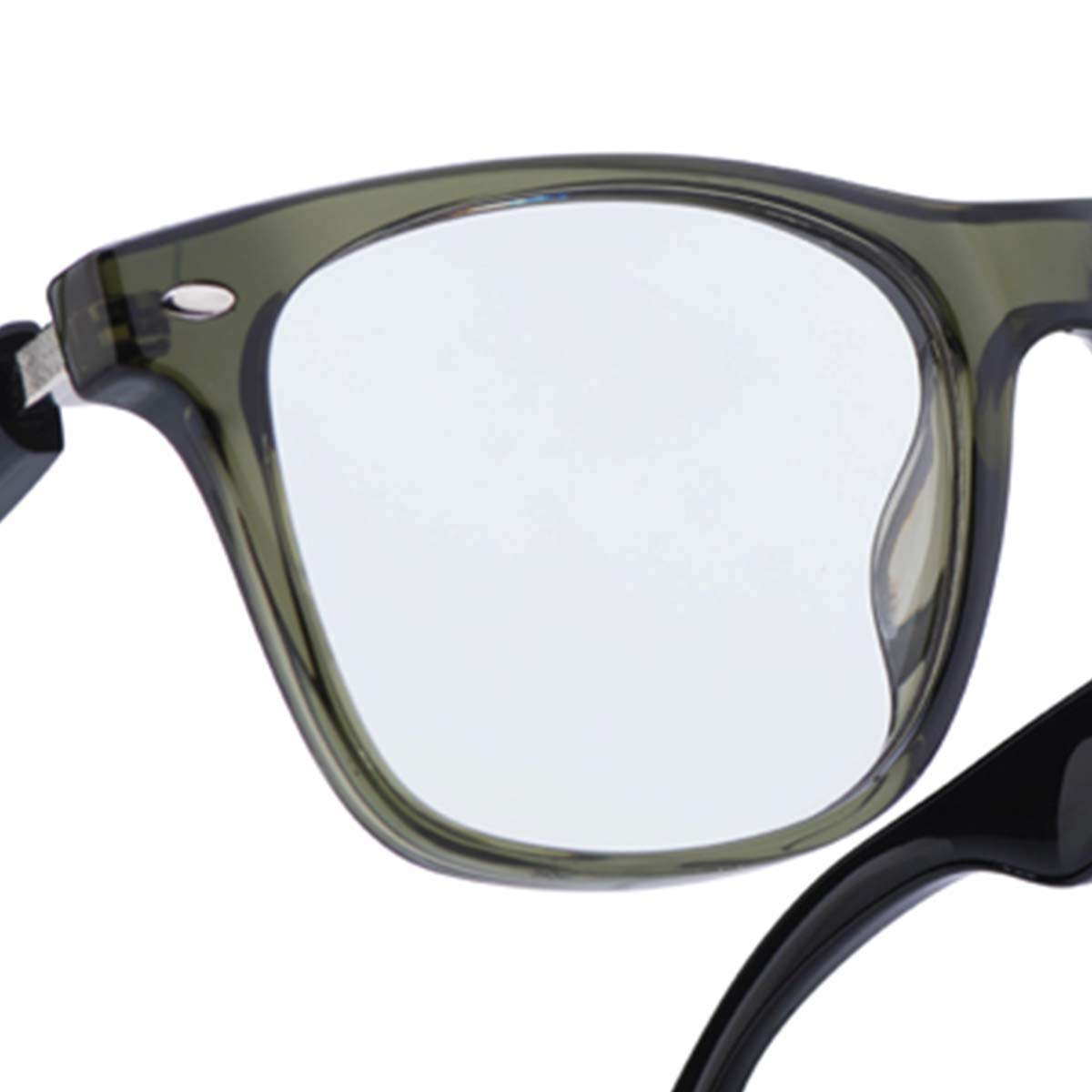 Nahaufnahme einer Brille. Olivgrüner Rahmen mit klaren Gläsern. Schwarzer Bügel rechts. Silbernes Scharnier links.