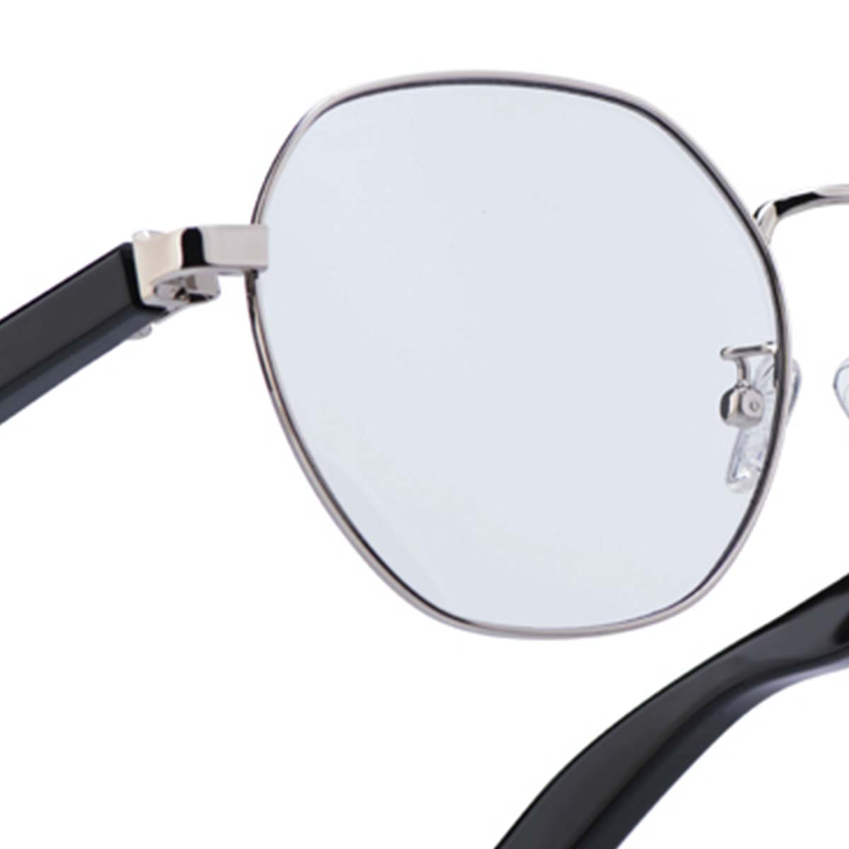 Nahaufnahme einer Brille. Silberne Fassung mit klaren Gläsern und schwarzen Bügeln. Ein kleines Metalldetail verbindet das Glas mit dem Bügel.