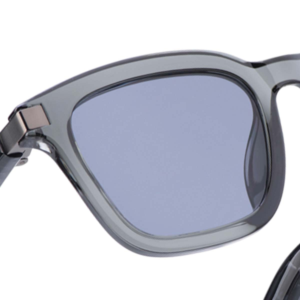 Nahaufnahme einer grauen Sonnenbrille mit hellblauem Glas. Der Rahmen ist dick und kantig.