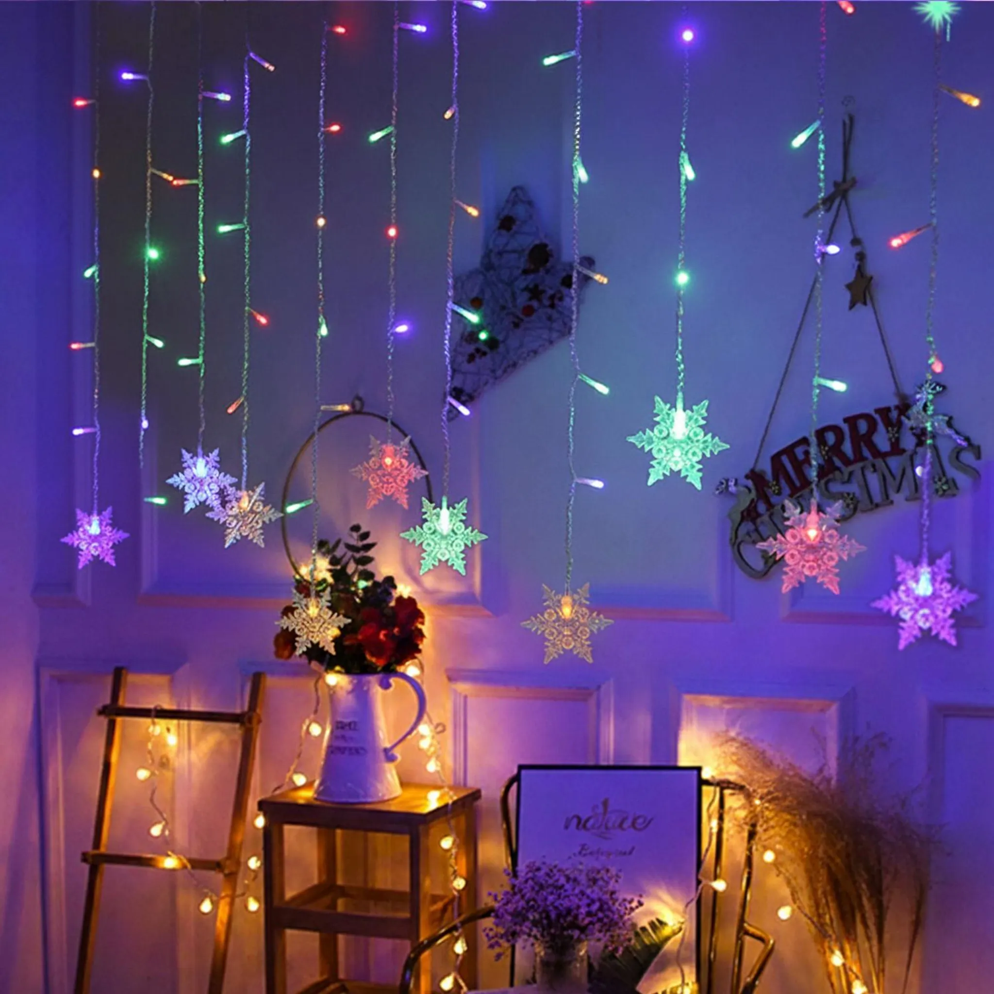 Ein Raum mit Weihnachtsbeleuchtung, Schneeflocken-Ornamenten und einem Frohe Weihnachten-Schild. Vordergrund hat Blumen und eine Leiter.