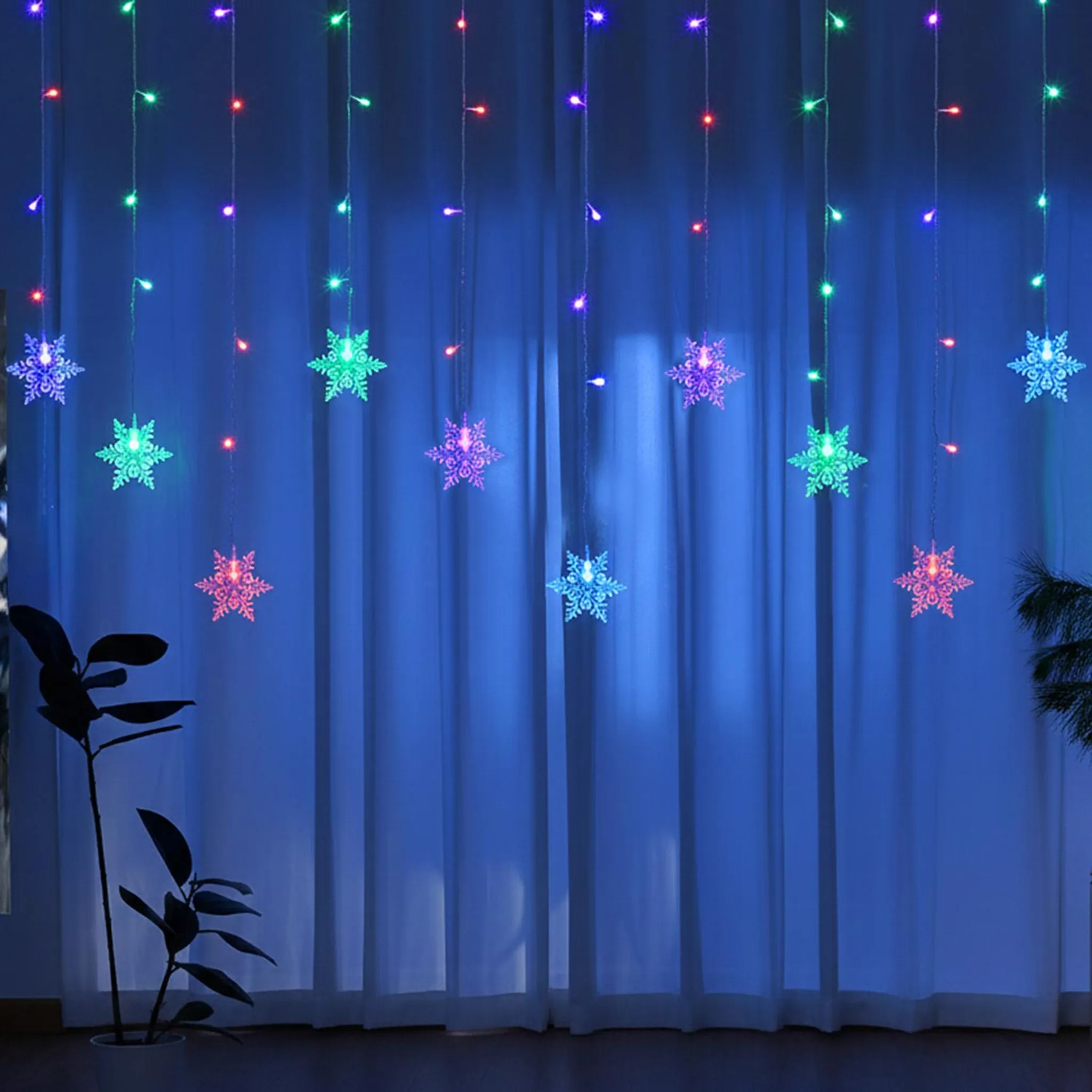 Ein Vorhang mit Schneeflockenlichtern. Die Lichter haben rote, grüne und blaue Farben.