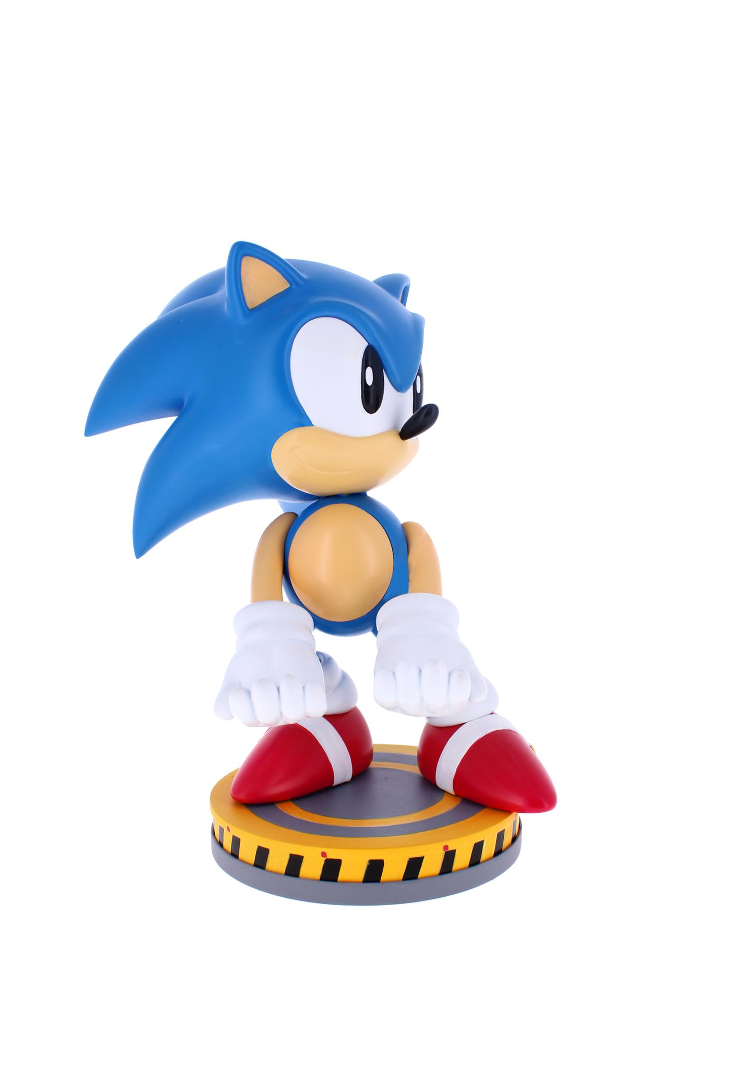 Sonic the Hedgehog Figur steht auf einem gelb-grauen Sockel. Er hat blaue Stacheln, weiße Handschuhe und rote Schuhe.