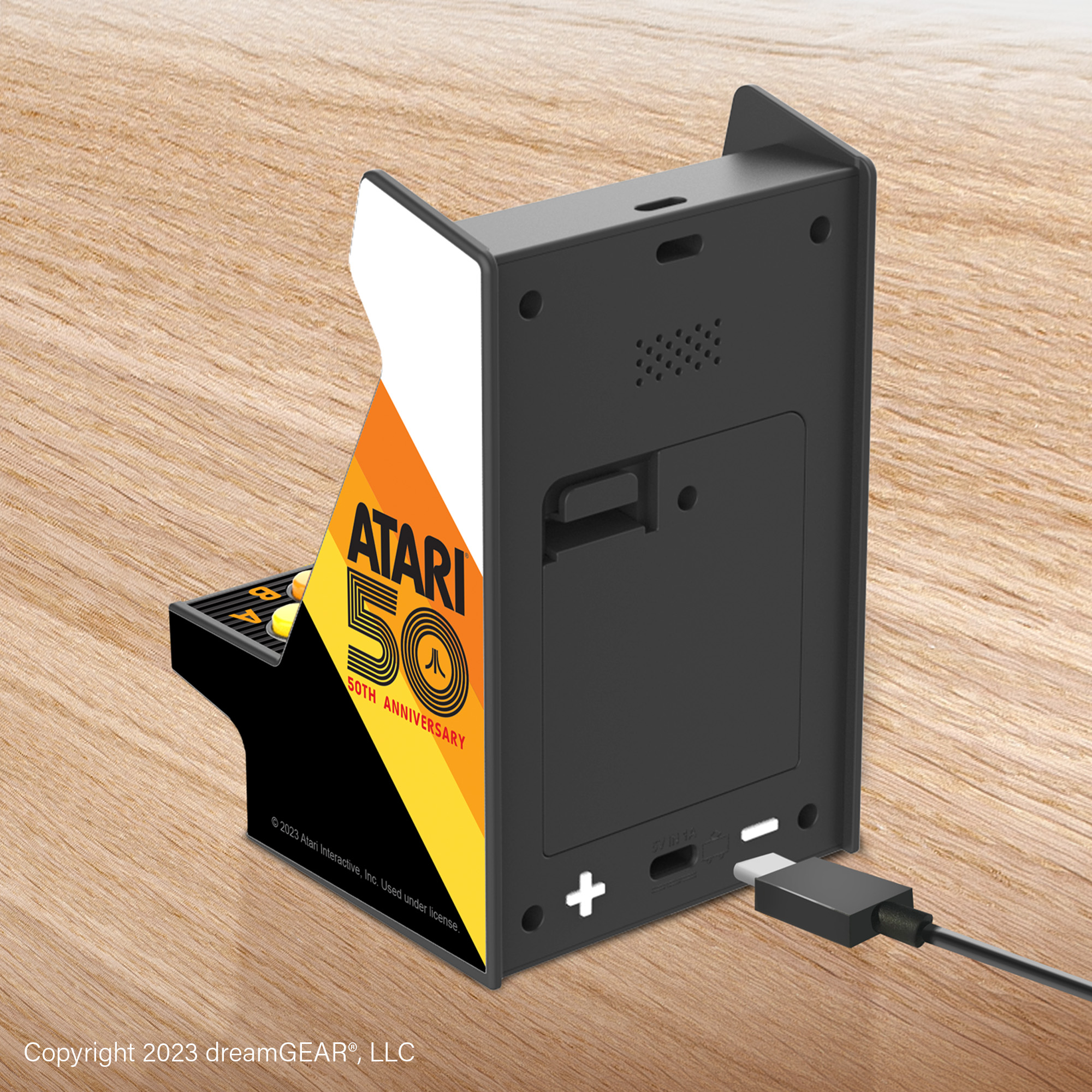 Una mini máquina arcade Atari. Tiene un cuerpo negro, un frente colorido con el logo de Atari y un fondo de superficie de madera.