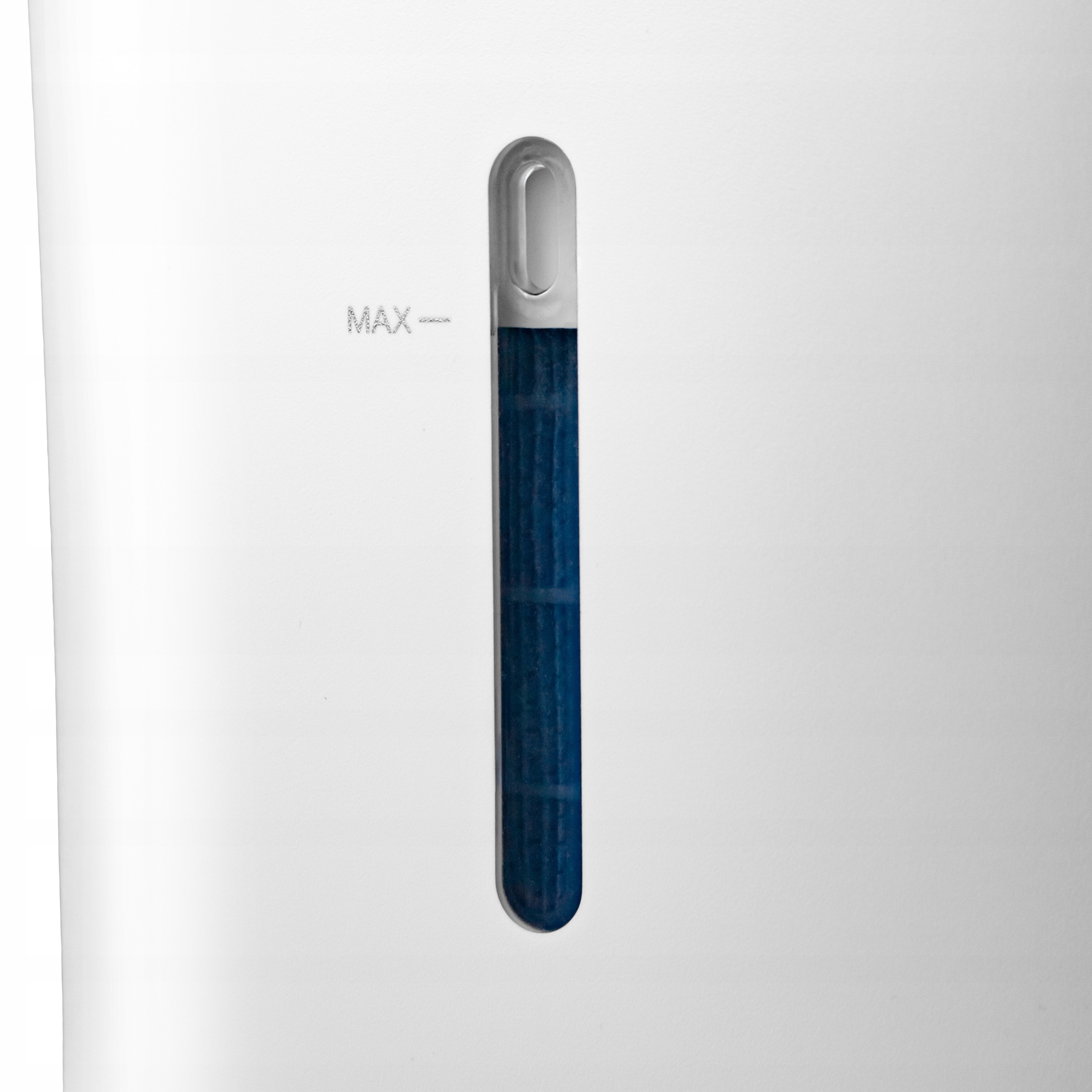 Białe urządzenie z niebieskim wskaźnikiem poziomu wody. Widoczny napis 'MAX'. Wskaźnik to przezroczysta rurka z niebieską zawartością.