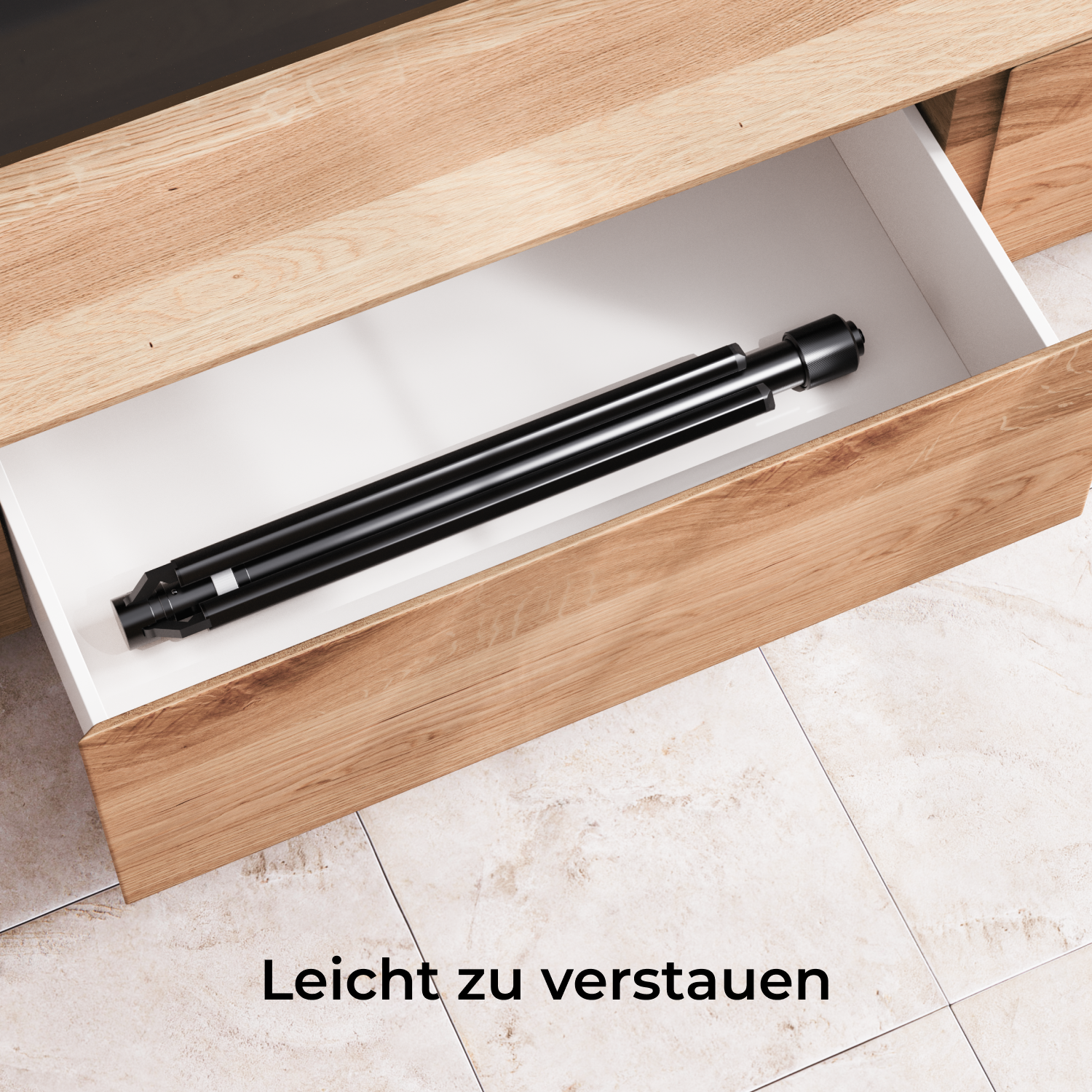 Ein schwarzes Objekt wird in einer Holzschublade aufbewahrt. Die Schublade ist offen und zeigt das Objekt im Inneren. Der Text 'Leicht zu verstauen' steht unten.