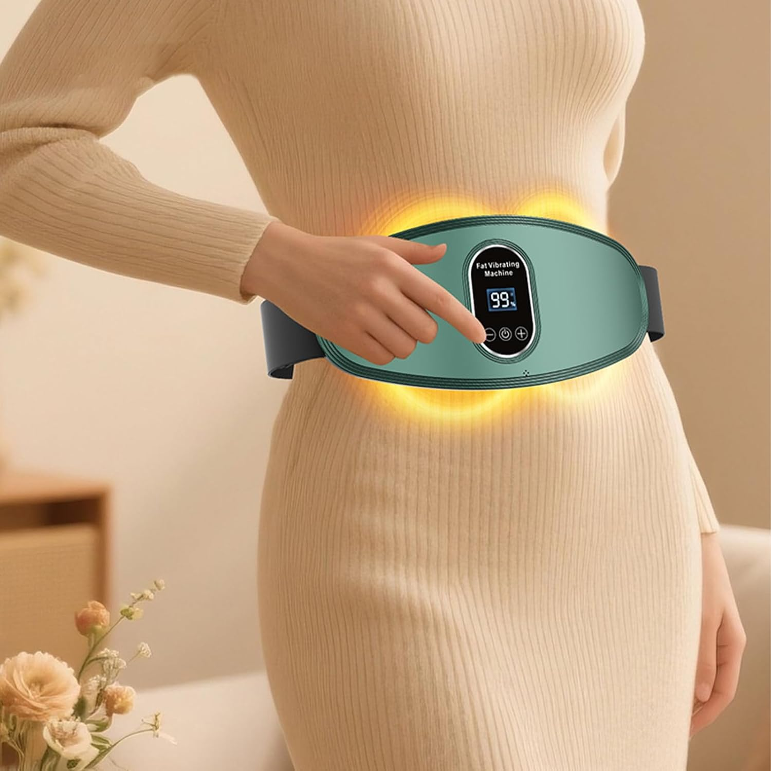 Frau in beigem Kleid, die einen grünen Fett-Vibrationsgürtel benutzt. Der Gürtel zeigt ein digitales Display mit der Nummer 99.