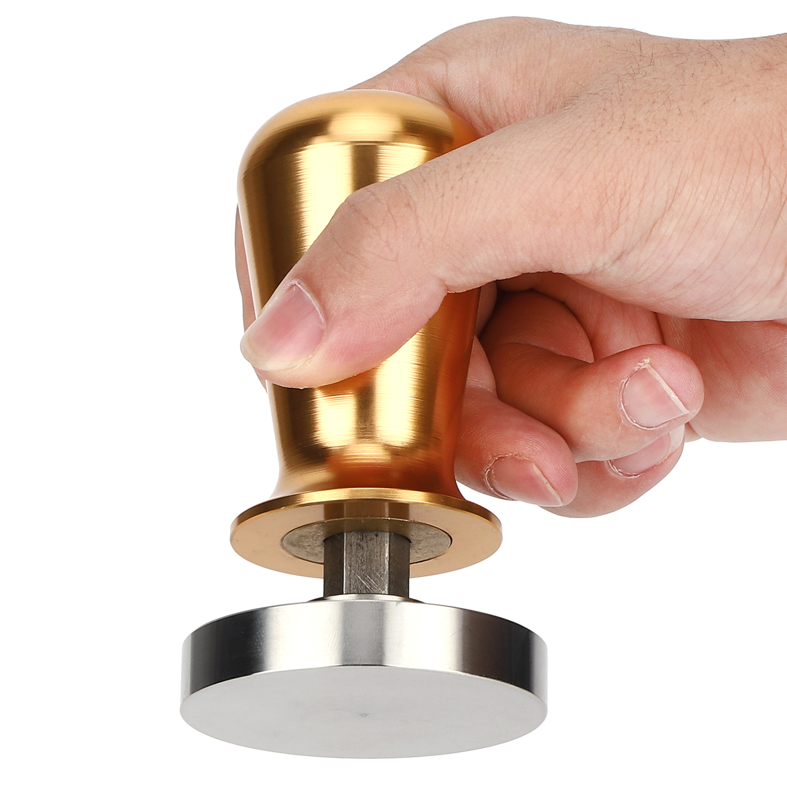 Eine Hand hält einen goldenen Kaffeestampfer. Der Stampfer hat einen silbernen Boden und sitzt vor einem weißen Hintergrund.