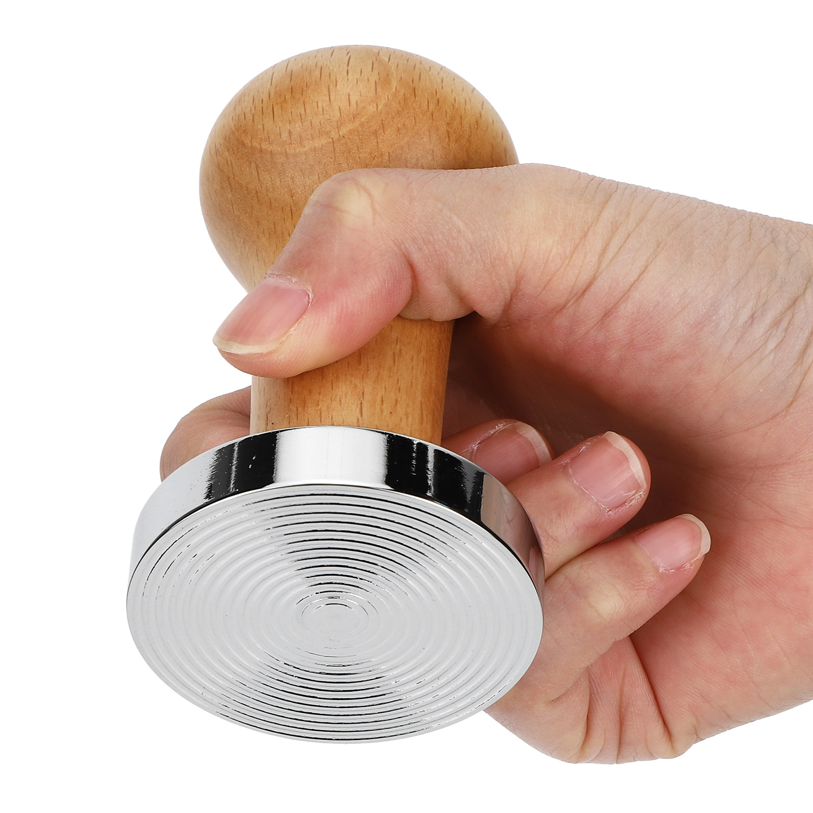 Eine Hand hält einen Kaffeestampfer. Er hat einen Holzgriff und eine silberne, geriffelte Basis. Der Hintergrund ist weiß.
