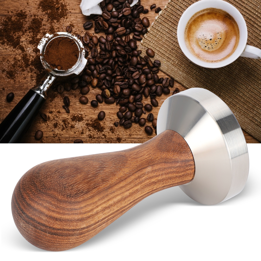 Kaffeezubereitung. Enthält Kaffeebohnen, Espressomehl, eine Tasse Kaffee und einen Kaffeetampfer mit Holzgriff.
