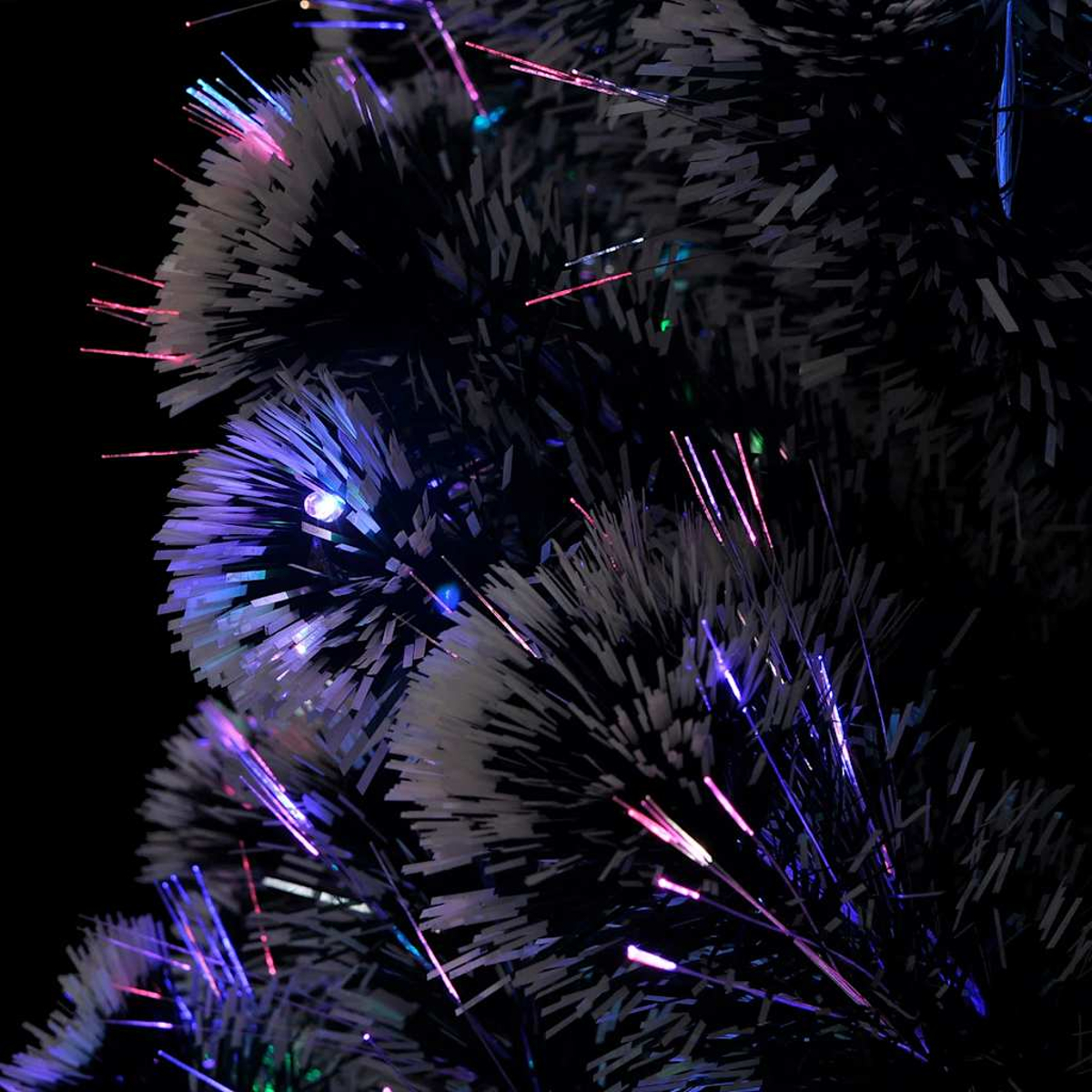 Primo piano di un albero di Natale in fibra ottica. Aghi neri con punte bianche e luci colorate.