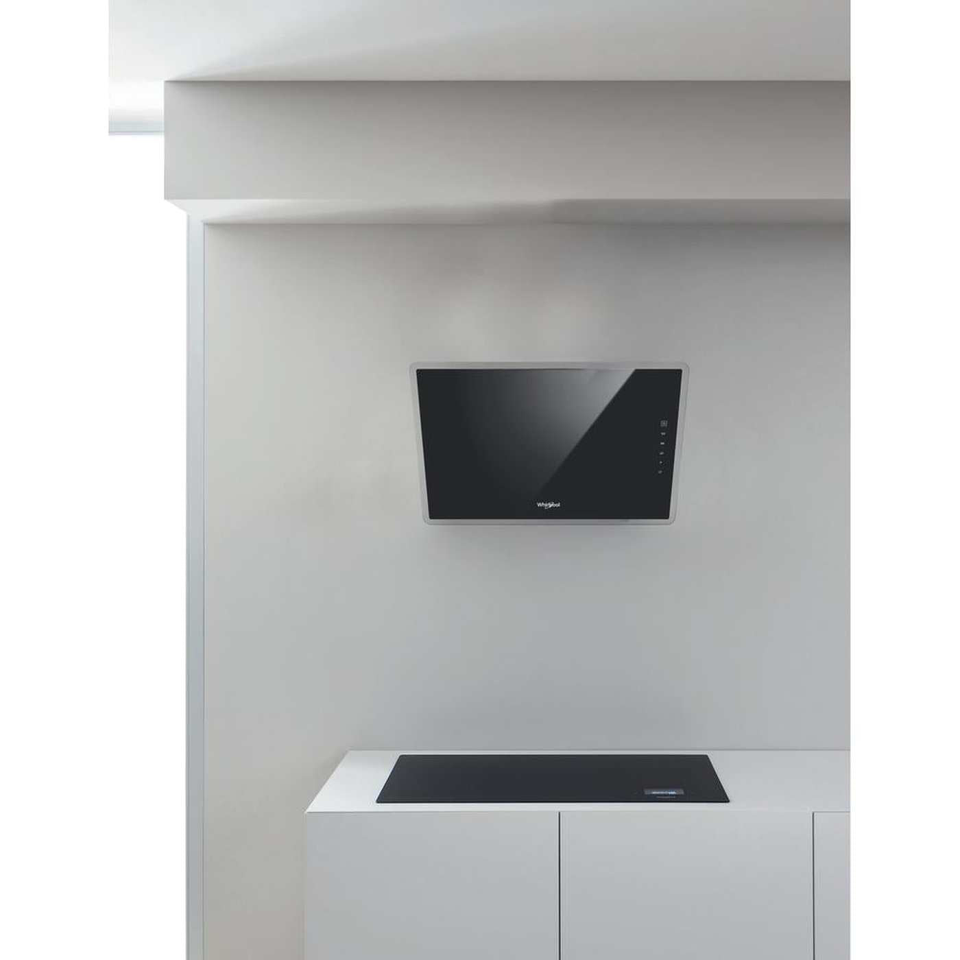Een moderne keuken met een zwarte afzuigkap en kookplaat. De muur en kasten zijn wit. De kap heeft een zilveren frame.