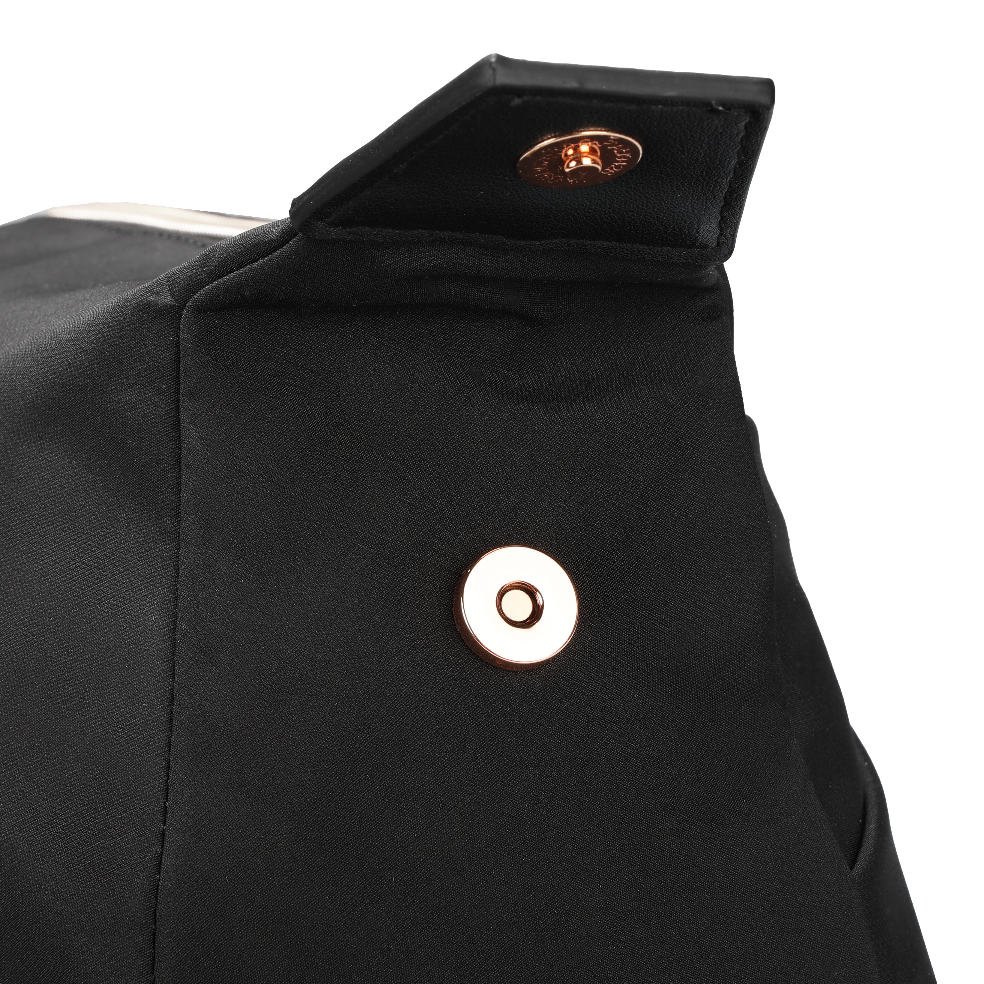 Primo piano di una borsa nera con chiusura dorata. Su sfondo bianco. Aletta superiore e chiusura magnetica visibili.