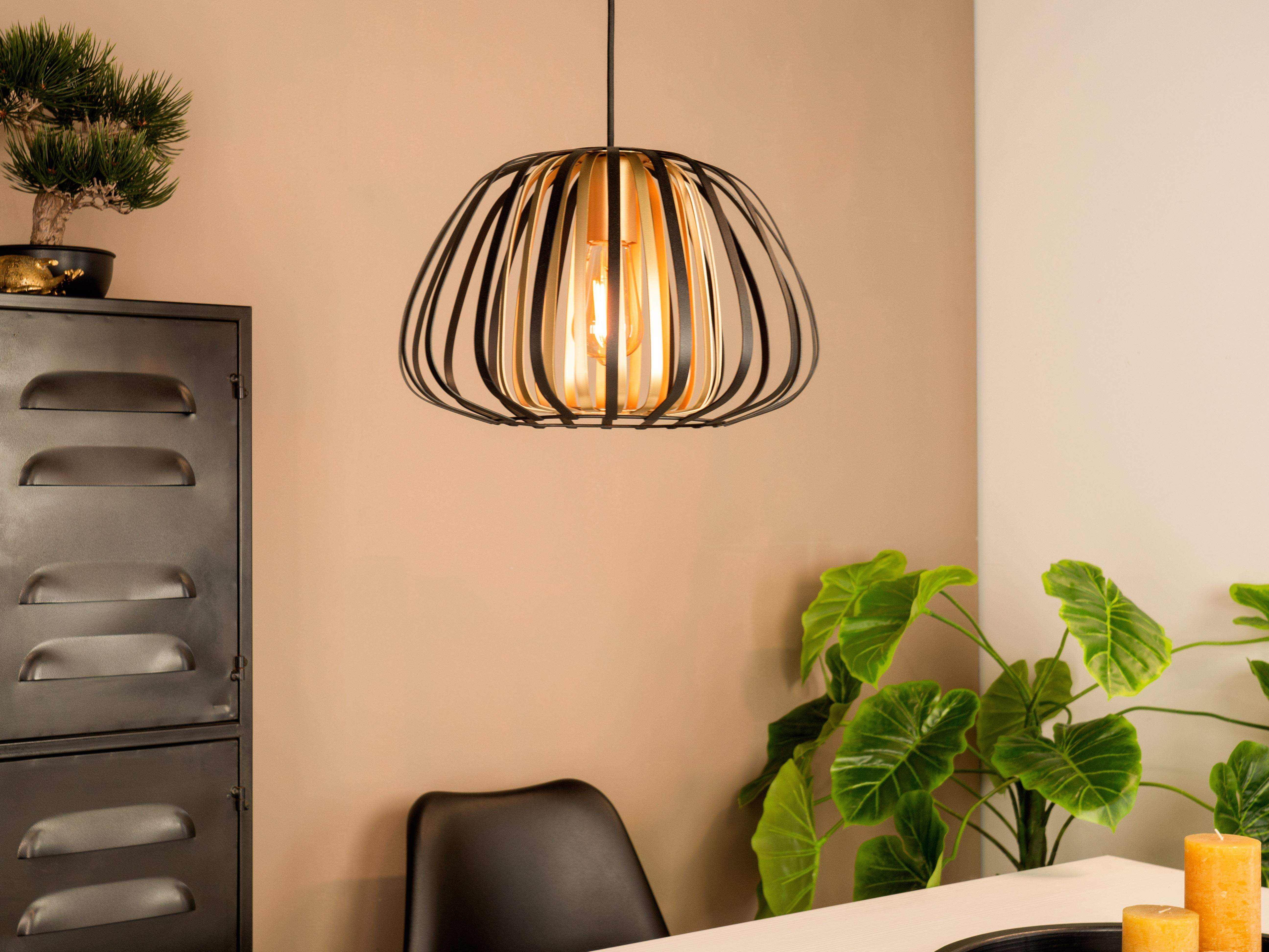 Ein modernes Interieur mit Lampe, Schrank, Pflanzen und Kerzen auf einem Tisch. Die Szene ist gut beleuchtet.
