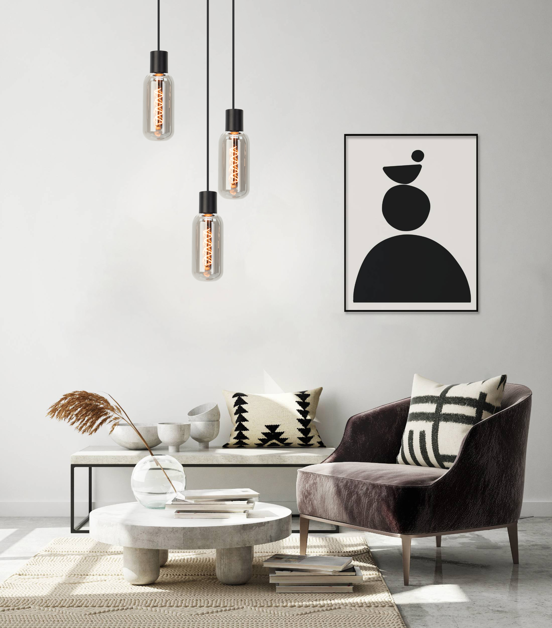 Un soggiorno moderno con lampade a sospensione, un'opera d'arte in bianco e nero, un divano e un tavolino con libri.