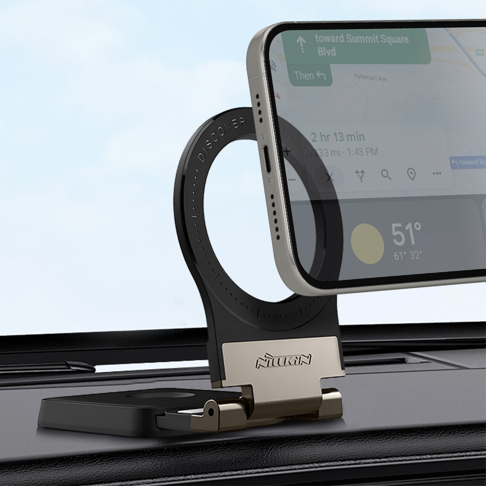 Un telefono in un supporto per auto mostra un'app di navigazione. Il supporto è nero e oro. Lo sfondo è un interno di un'auto.
