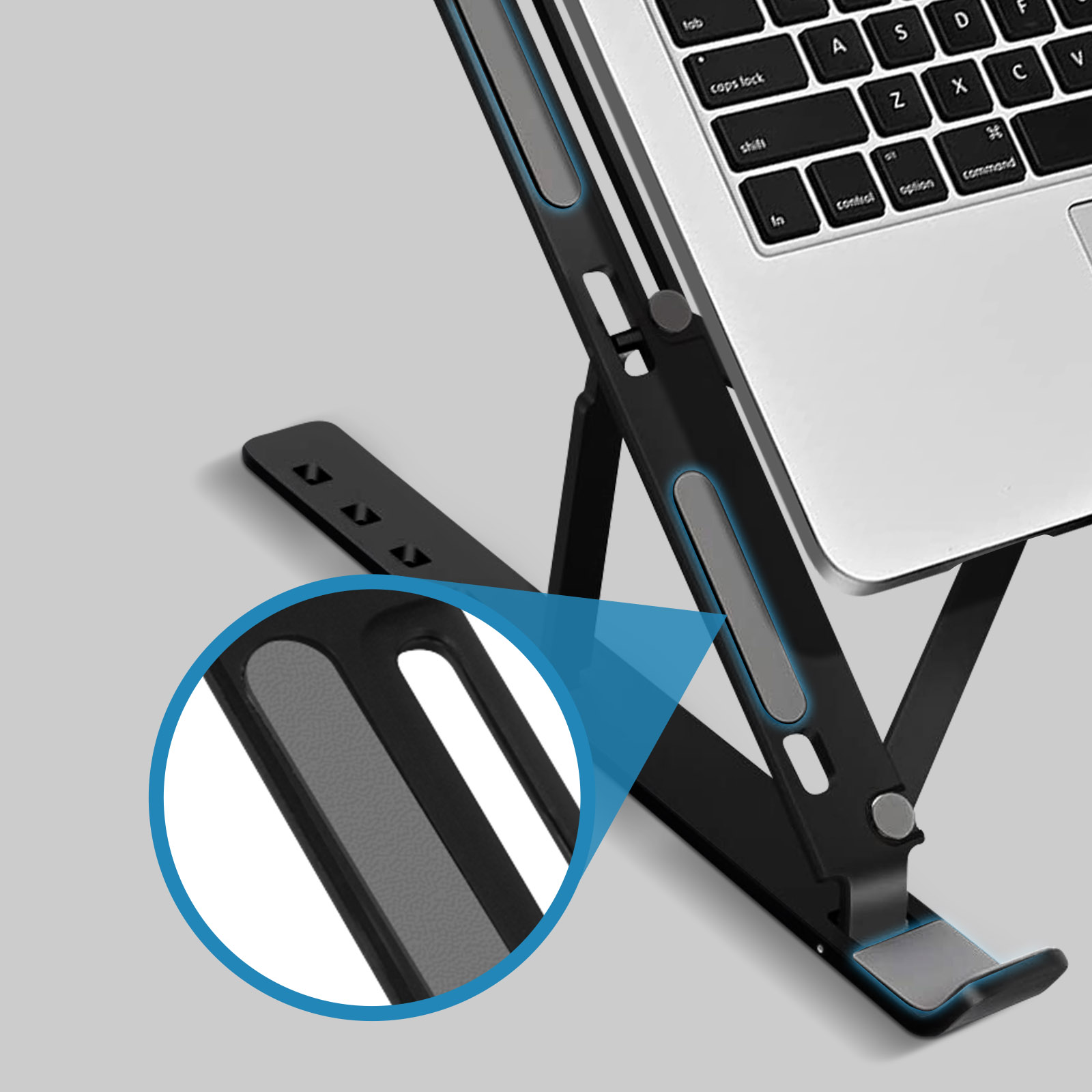 Ein Laptop auf einem schwarzen Ständer. Der Ständer hat einen grau gepolsterten Bereich. Nahaufnahme zeigt das Design des Ständers.