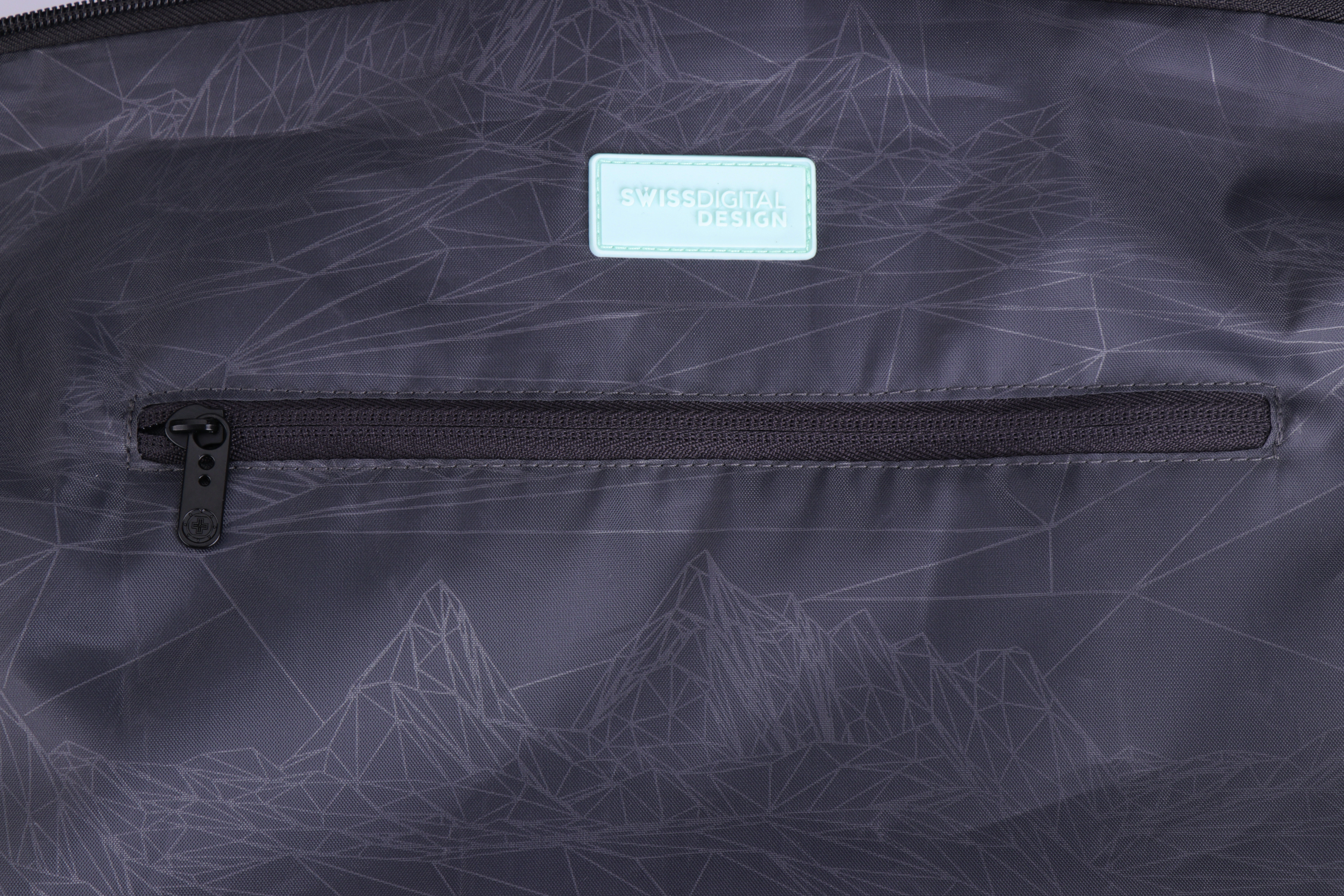 Interno borsa grigio scuro con cerniera e etichetta azzurra con SWISSDIGITAL DESIGN.