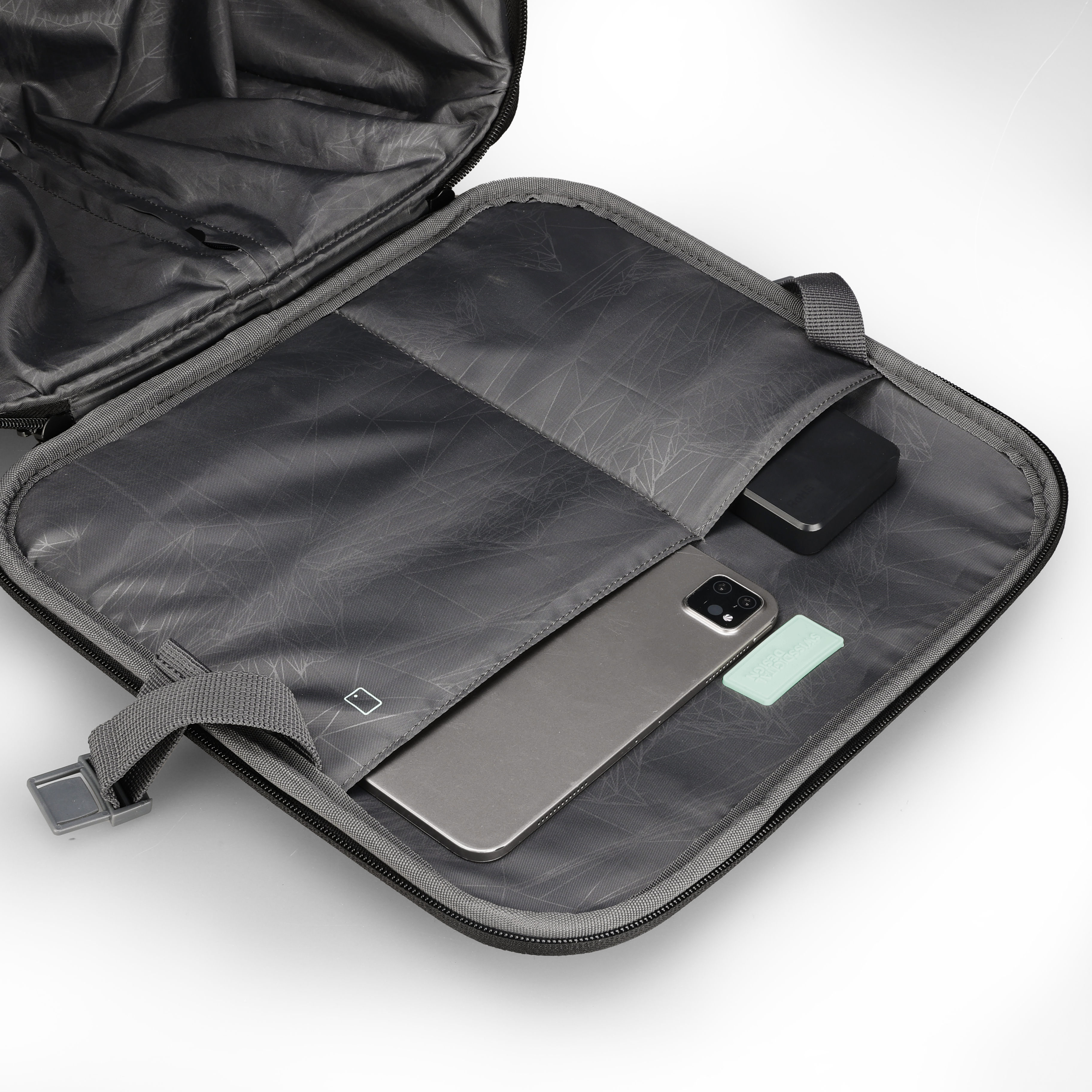 Borsa per laptop grigia aperta con telefono, power bank e oggetto verde menta. Sfondo bianco.