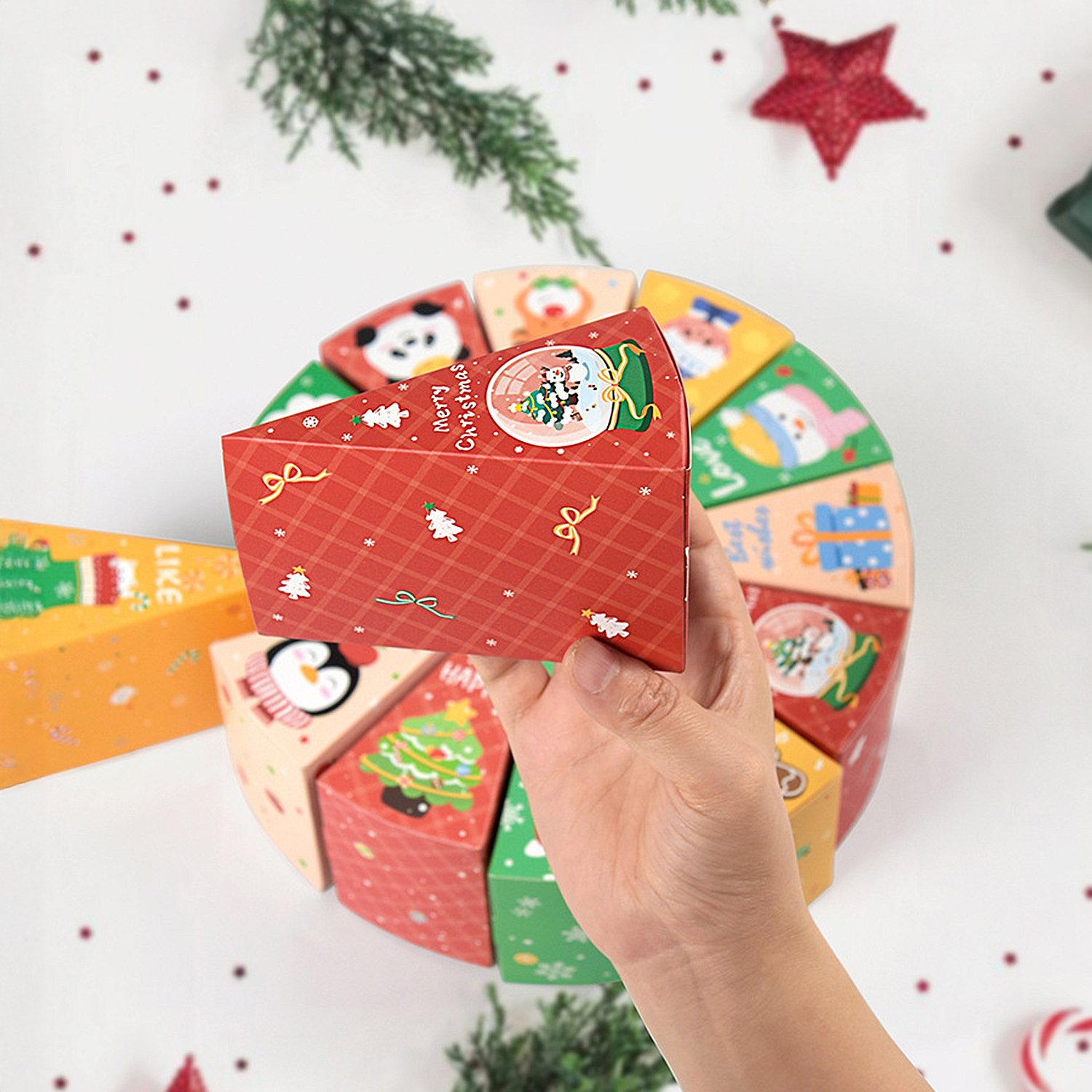 Eine Hand hält eine rote, weihnachtliche Box-Scheibe. Andere Scheiben bilden einen Kreis. Dekorationen umfassen einen Stern und eine Zuckerstange.