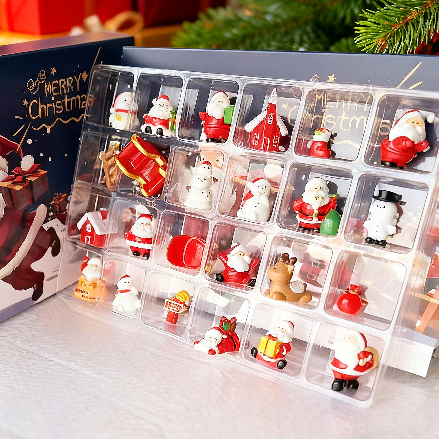 Ein Weihnachtskalender mit Santa, Schneemännern und festlichen Dekorationen in einzelnen Fächern. Eine Frohe Weihnachten Box ist sichtbar.