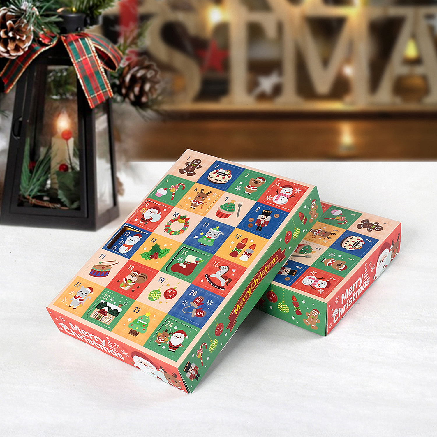 Zwei bunte Weihnachtskalender auf weißem Untergrund mit einer beleuchteten Laterne und Dekorationen im Hintergrund.