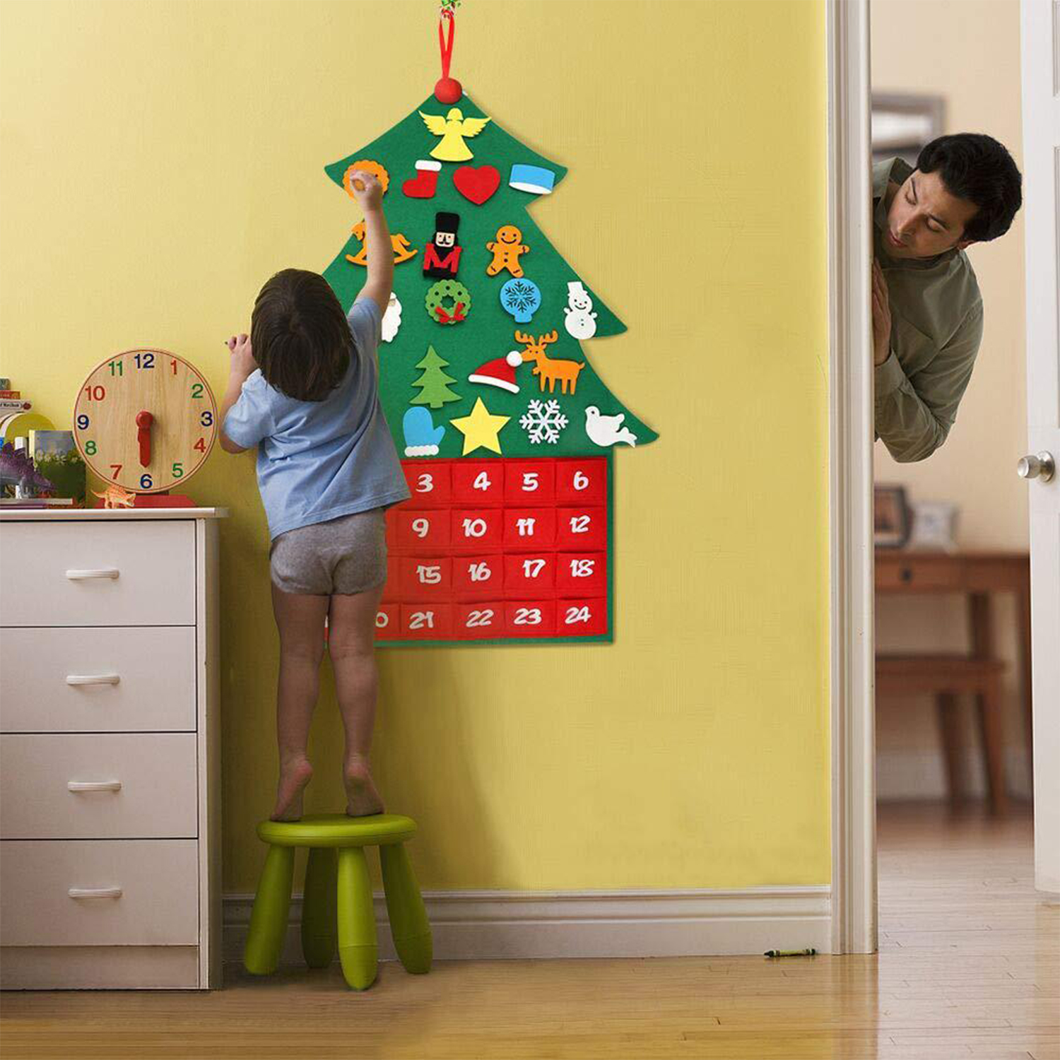 Ein Kind steht auf einem Hocker und greift nach einem Weihnachtskalender. Ein Mann schaut aus einer Tür. Eine Uhr und eine Kommode sind sichtbar.